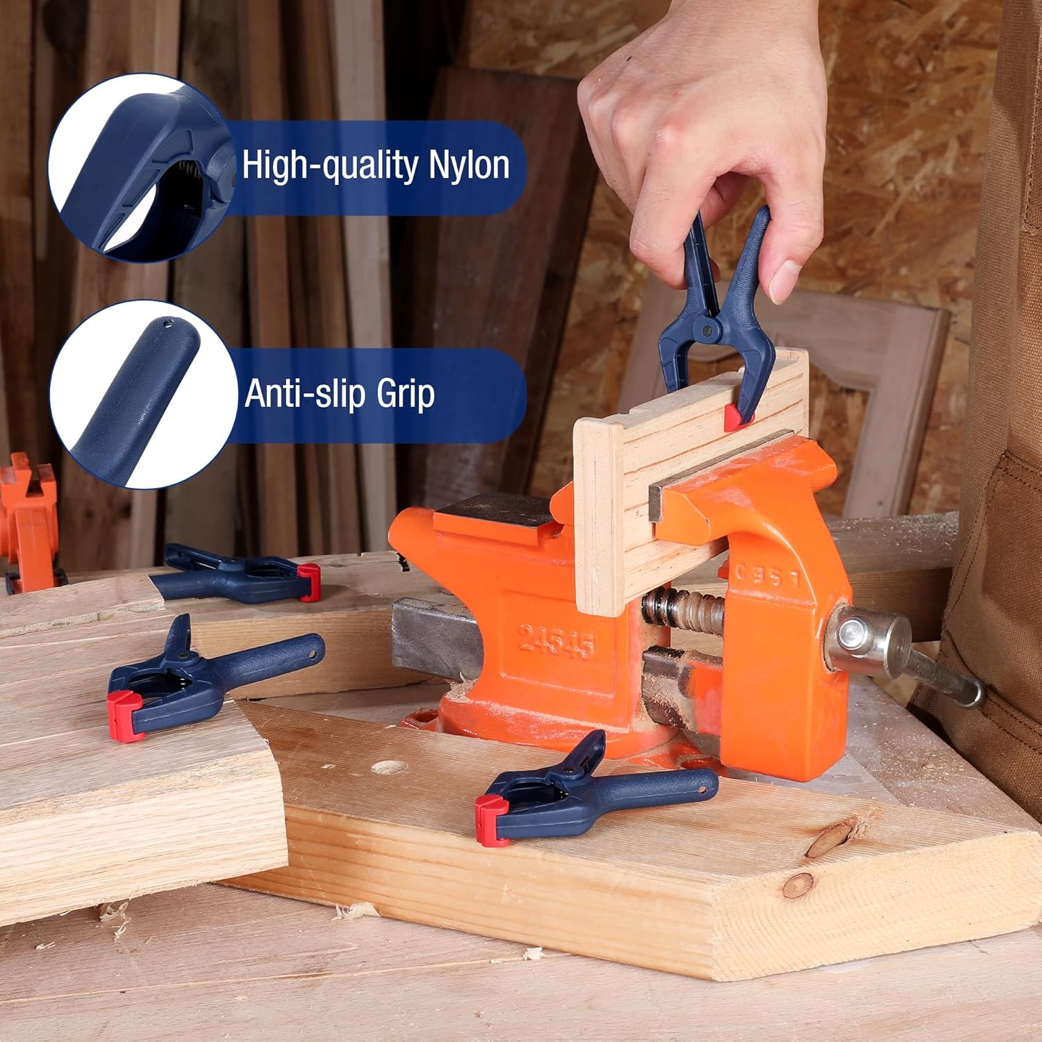 Dark blue nylon spring clamp with anti-slip grip and red pad tip, held on wood