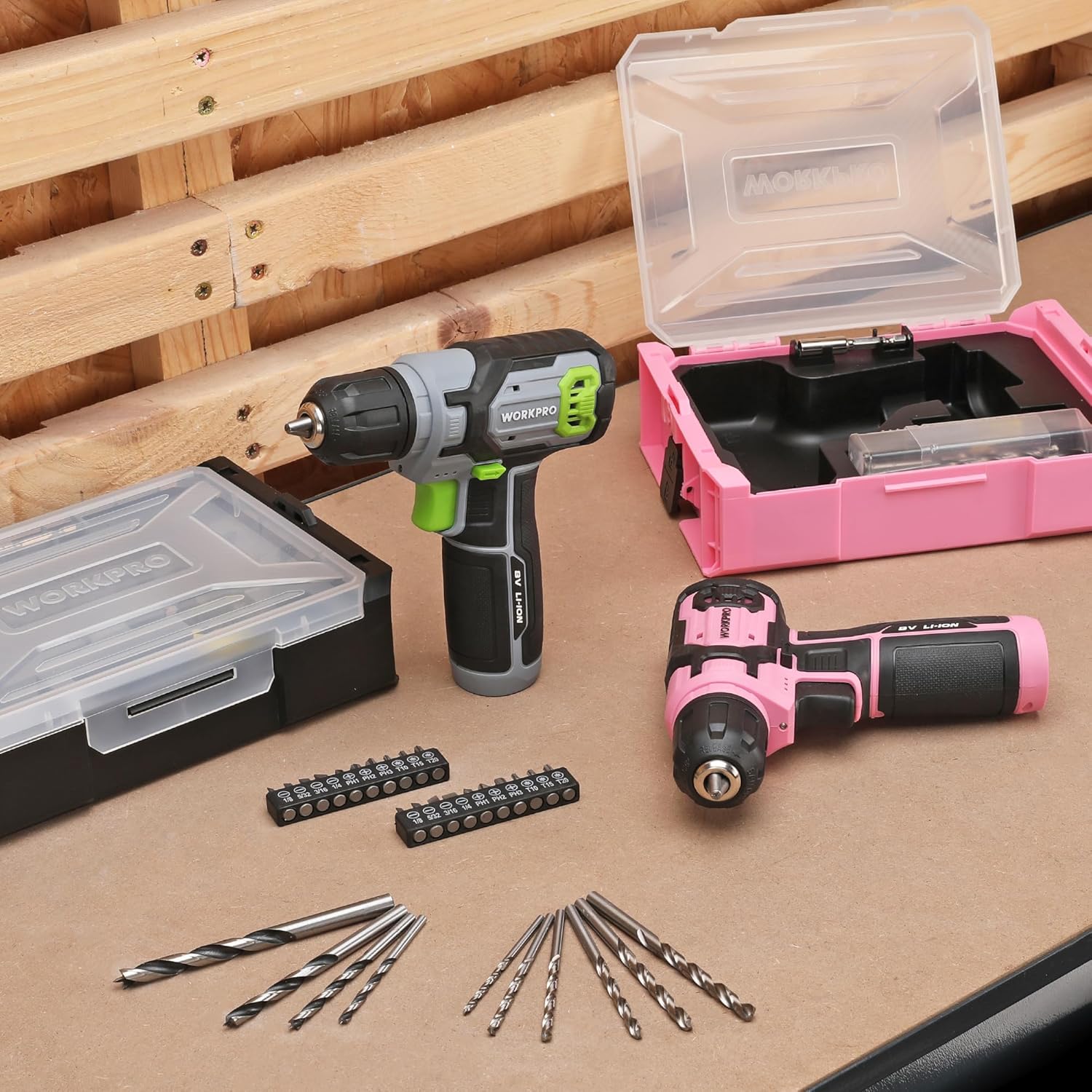 Pink cordless drill driver with keyless chuck and drill bits, shown with storage boxes