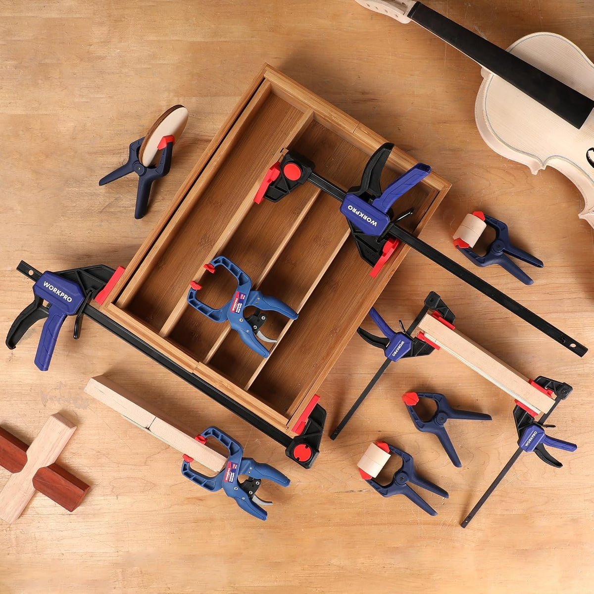 WORKPRO clamp set holding a wooden panel using multiple blue and black bar clamps