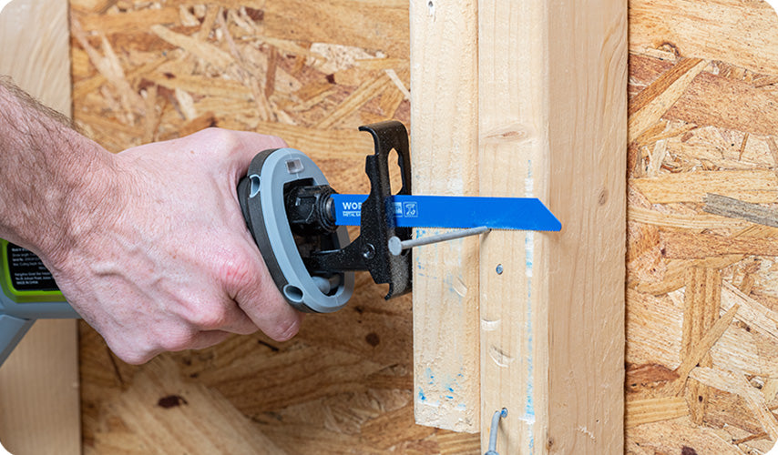 Reciprocating saw cutting through a wooden stud, with a blue blade and visible wood chips