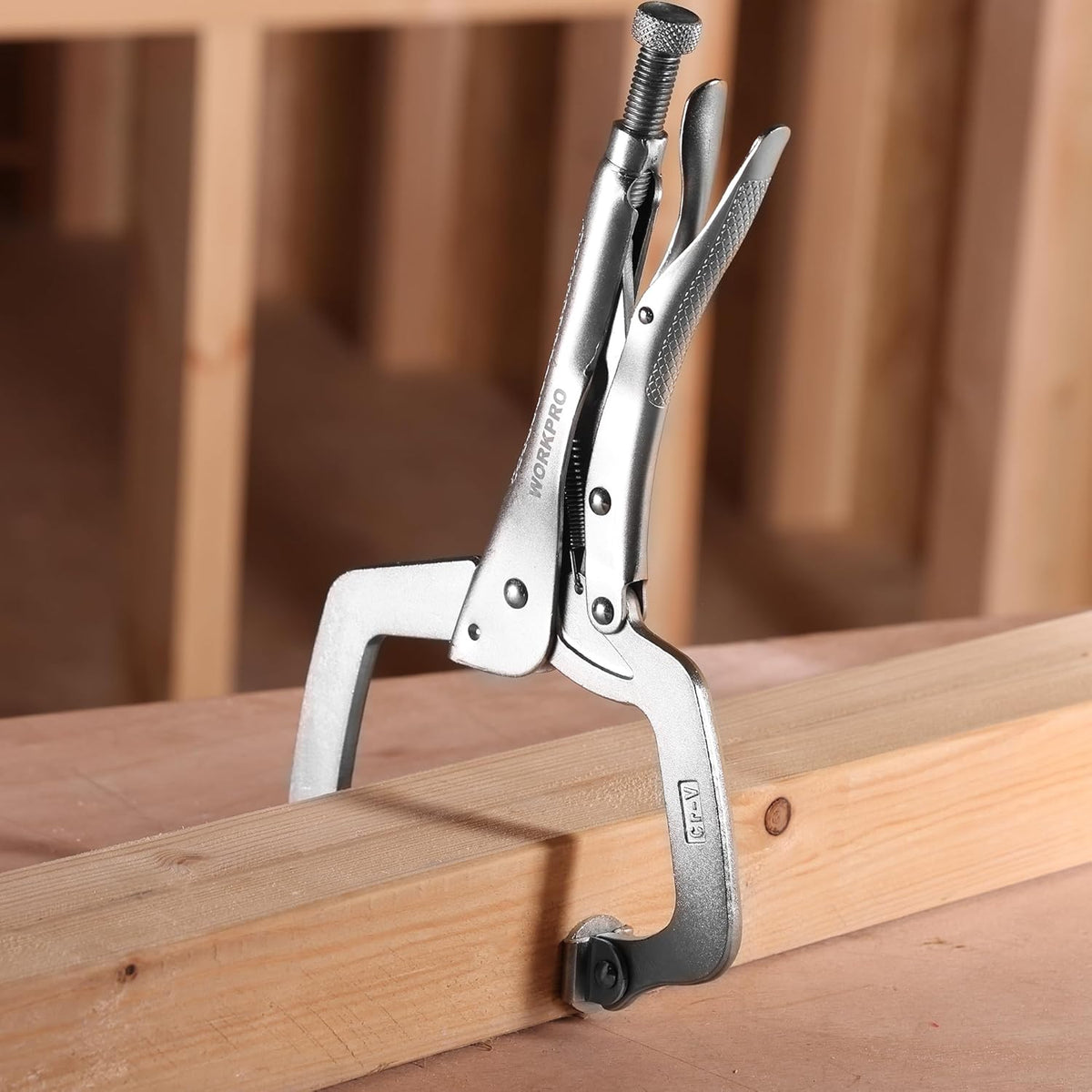 WORKPRO C-clamp locking onto a wood beam with threaded screw and swivel pad base