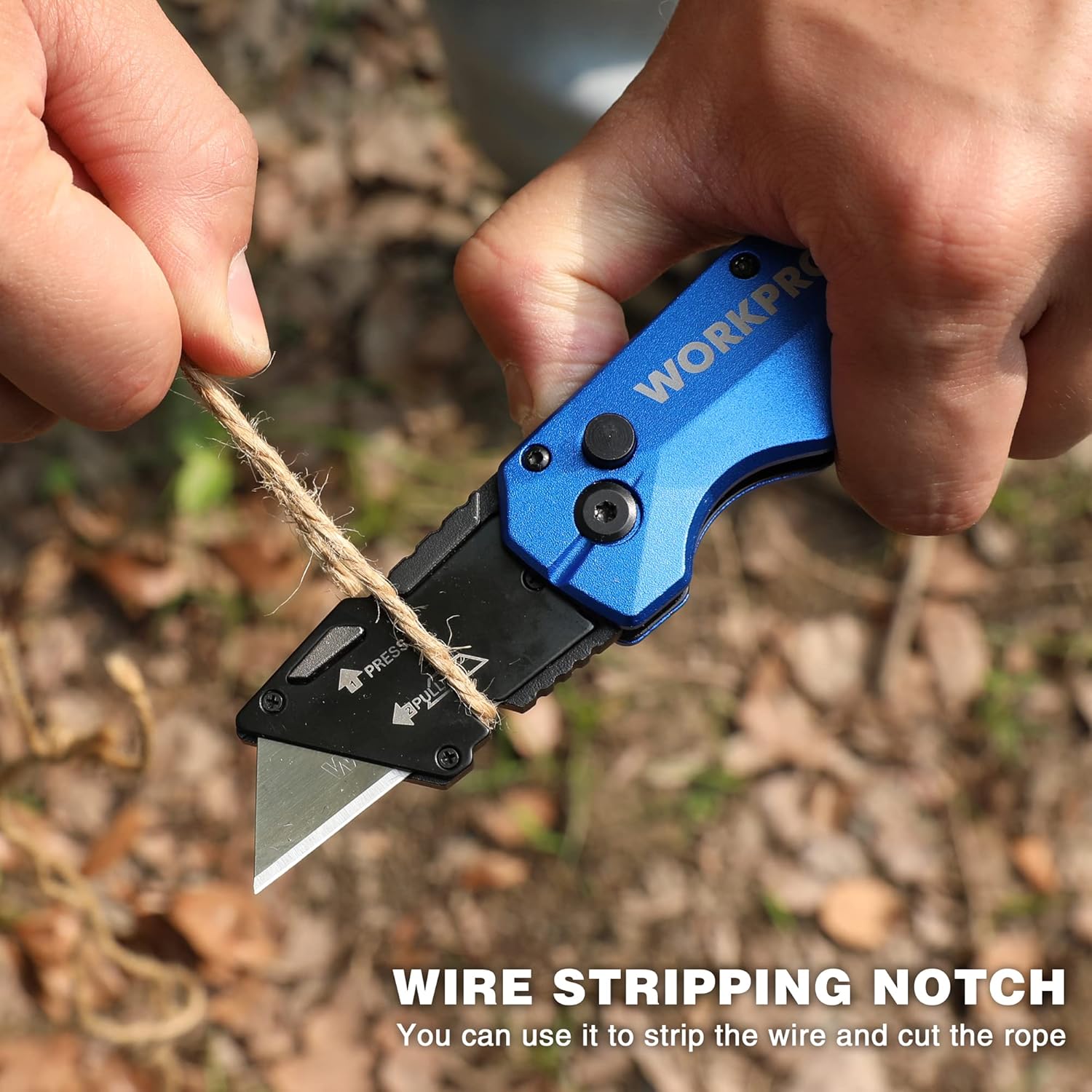 Blue and black folding utility knife cutting rope with wire-stripping notch