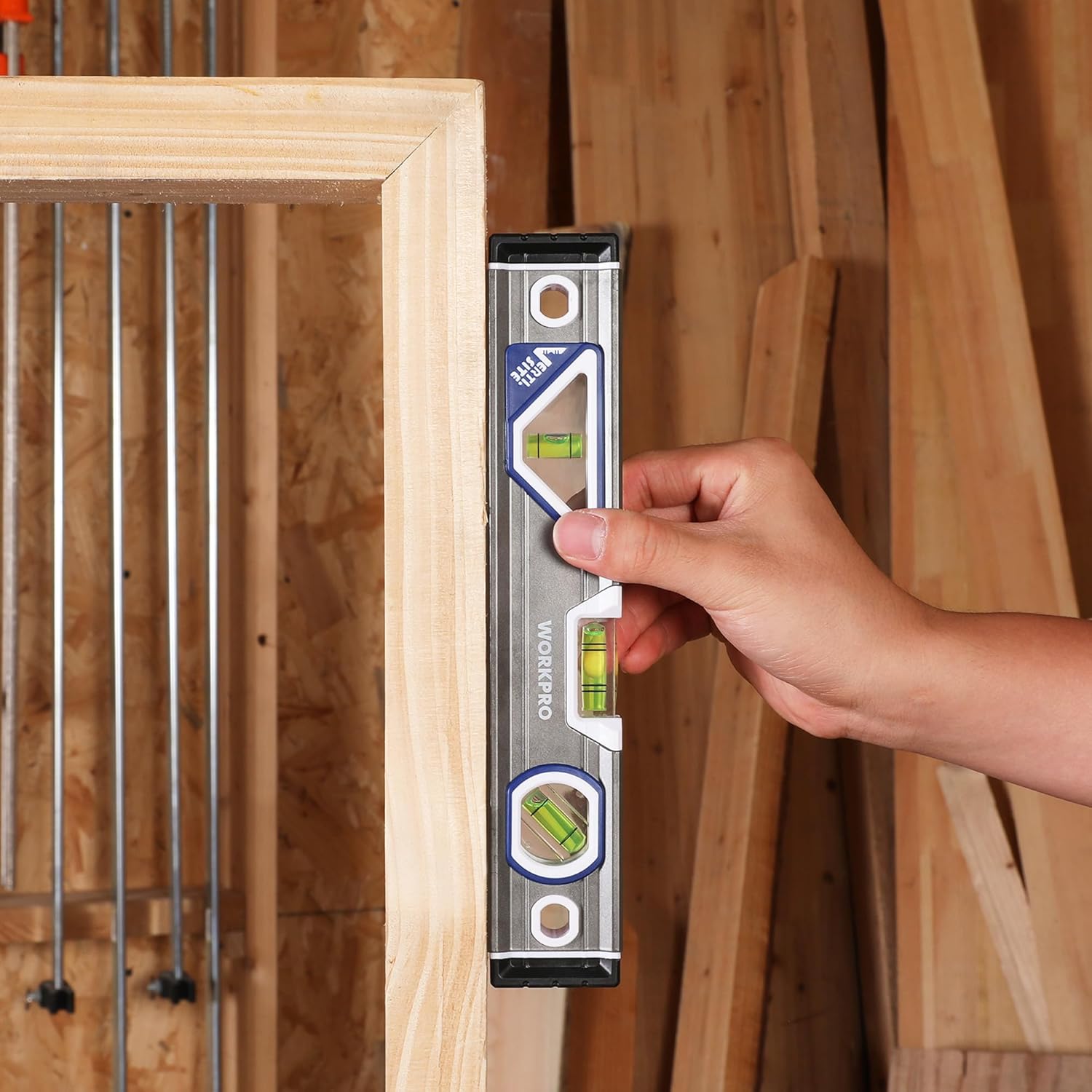 WORKPRO torpedo level with three bubble vials held against wooden beams