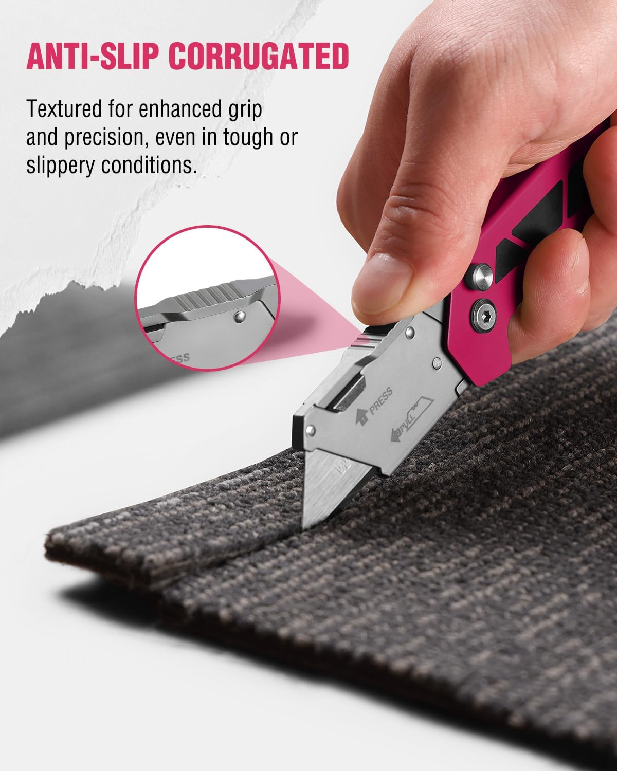 Pink folding utility knife cutting dark fabric, with textured grip