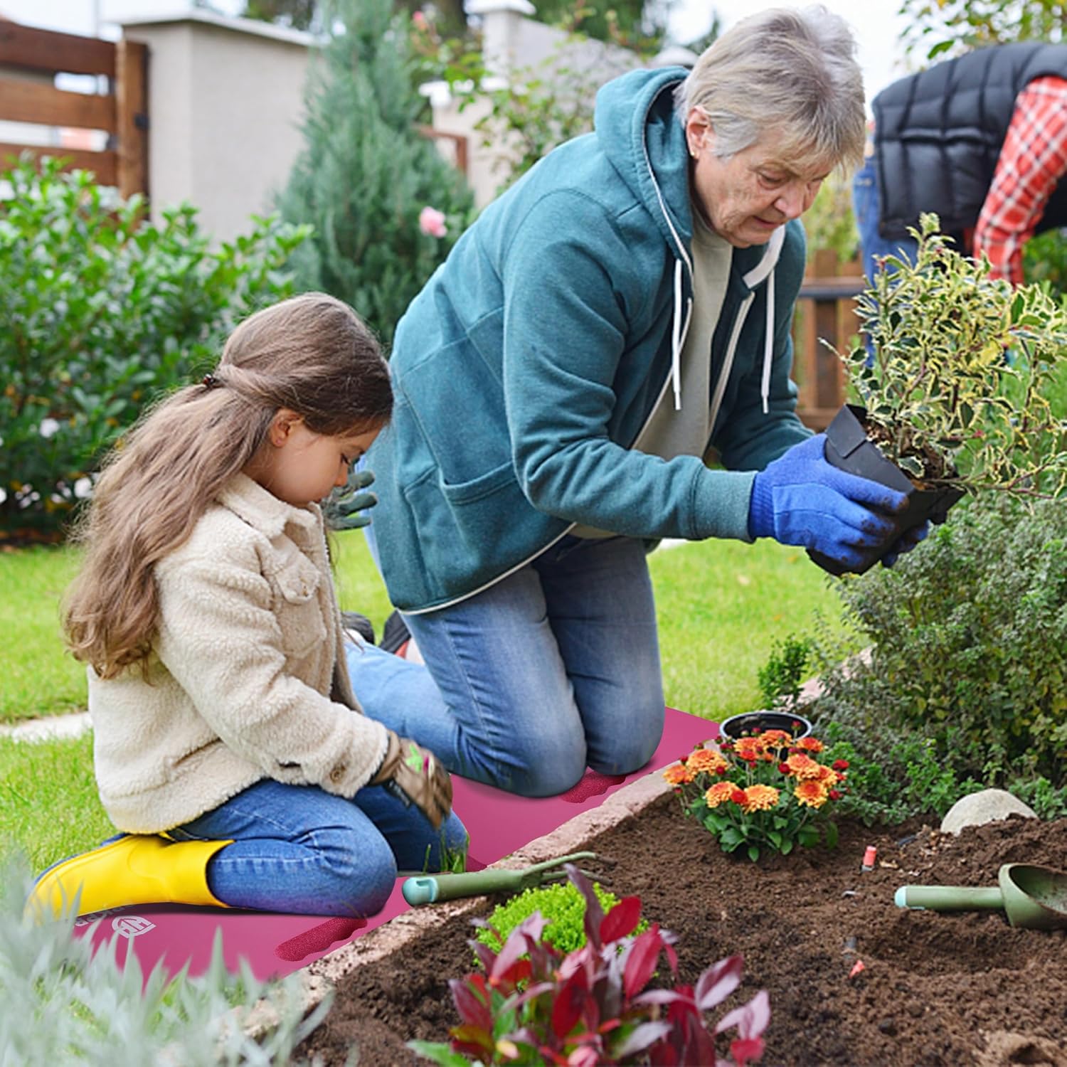 Teal extra-thick foam kneeling pad used while gardening among flowerbeds.