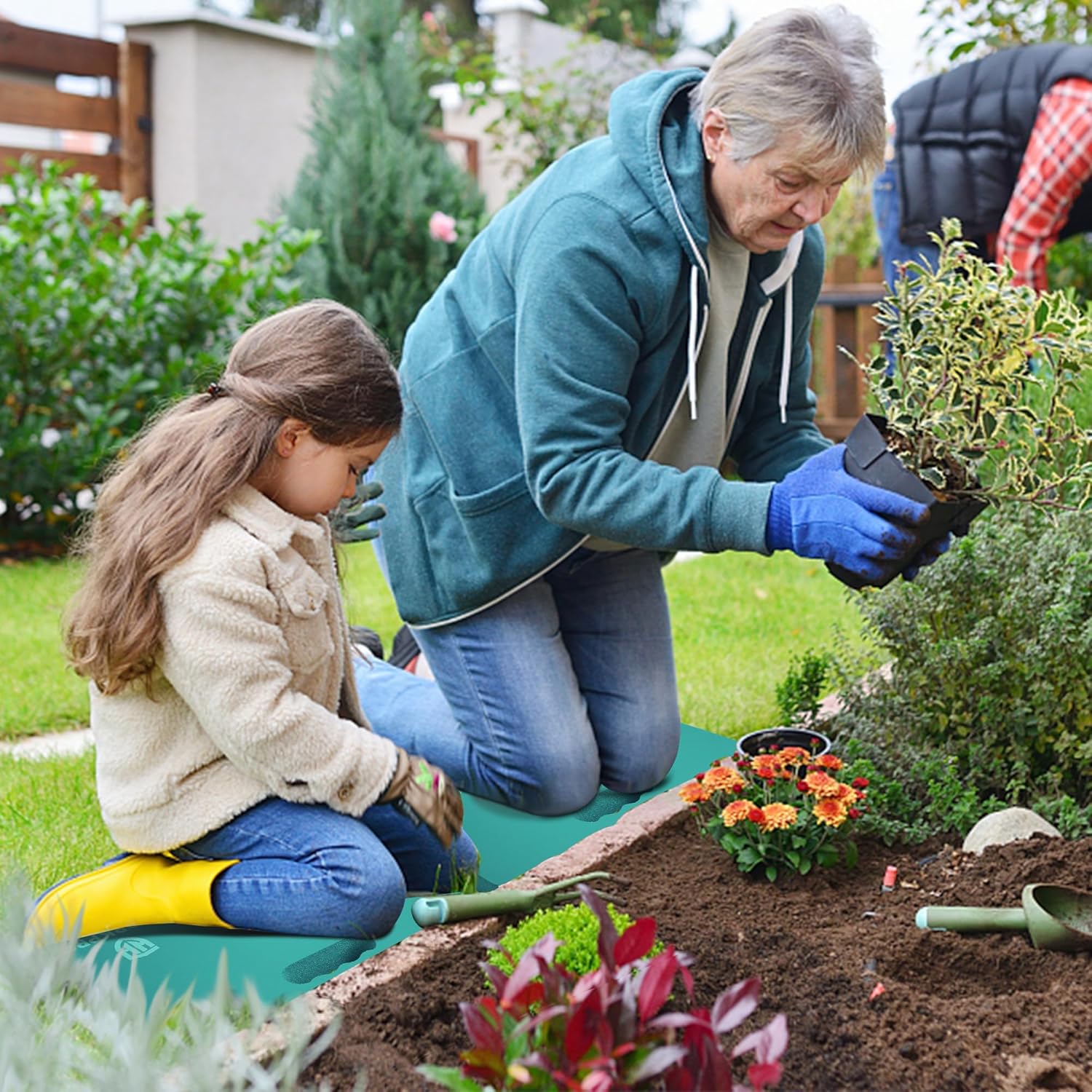 Teal foam kneeling pad on the ground while tending plants in a garden.