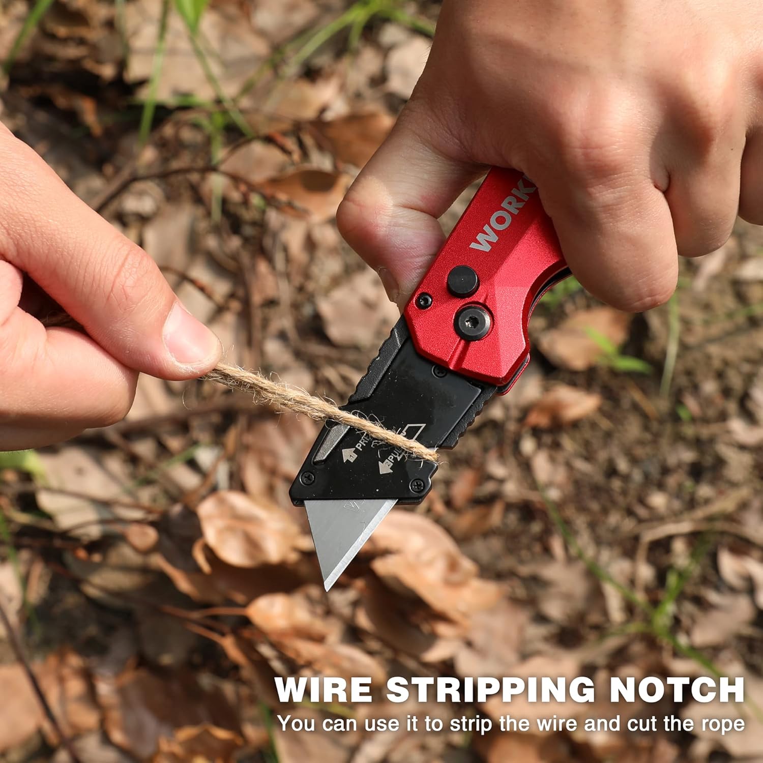 Red folding utility knife with wire-stripping notch cutting a rope