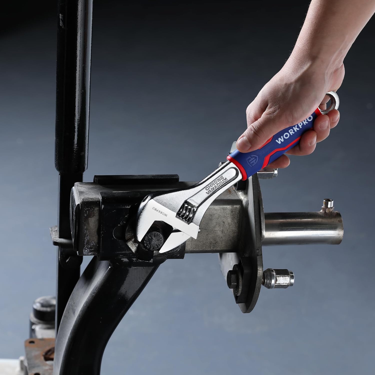 Adjustable WORKPRO wrench with TPR grip gripping a pipe fitting