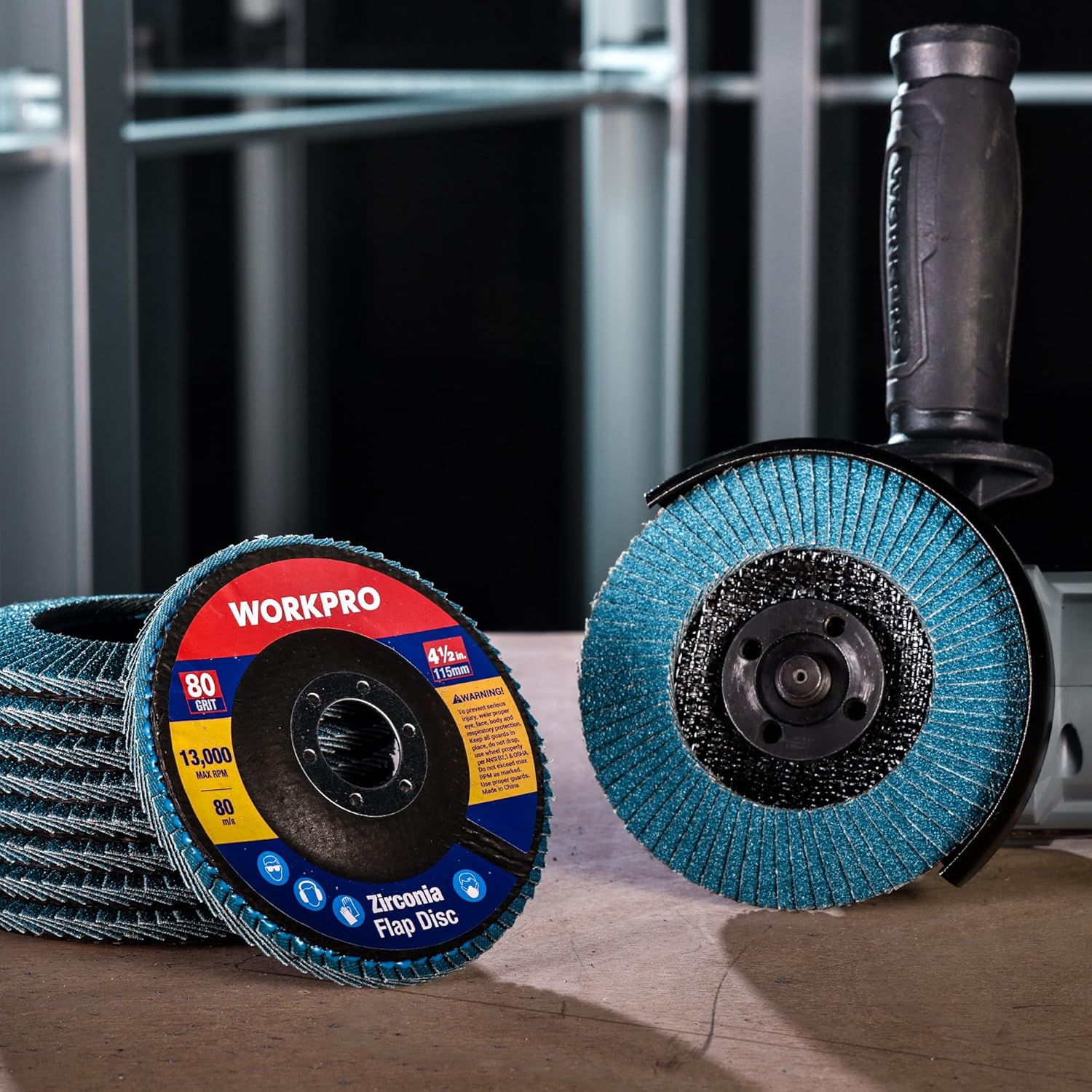 Two WORKPRO zirconia flap sanding discs on a workbench with teal abrasive flaps