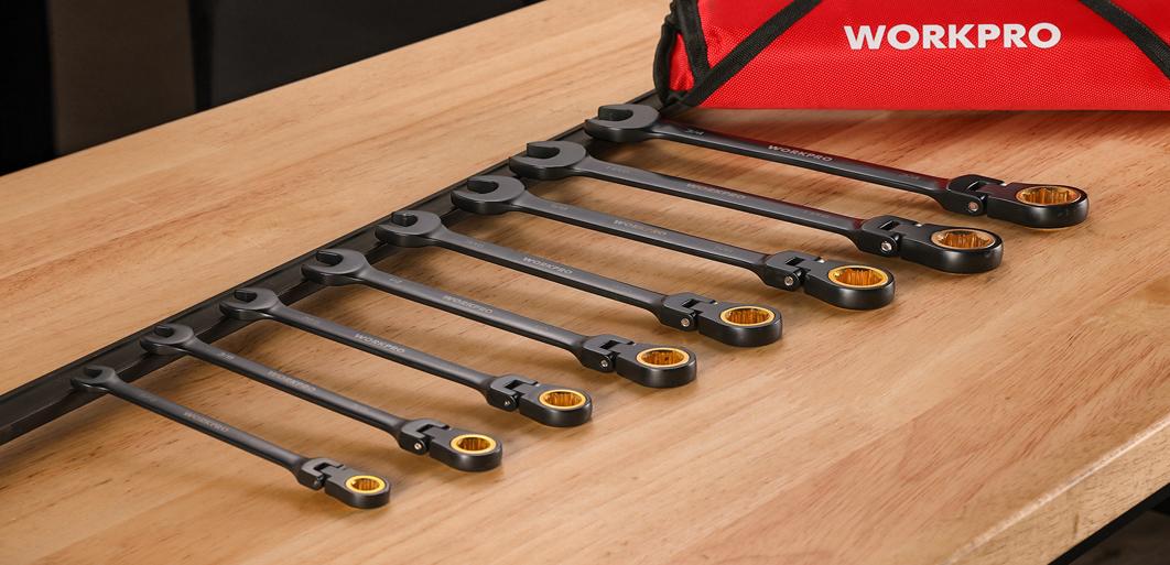 Set of WORKPRO wrenches on a wooden workbench, with orange ends and black handles