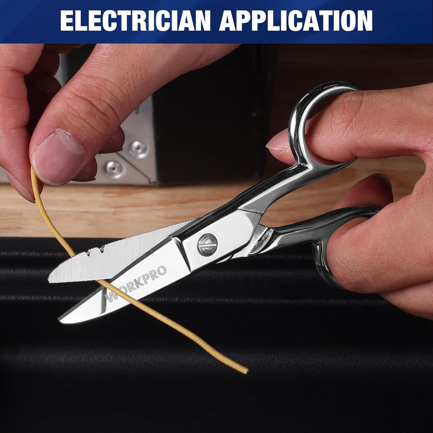 WORKPRO electrician scissors cutting a cable with finger loops and metal blades.