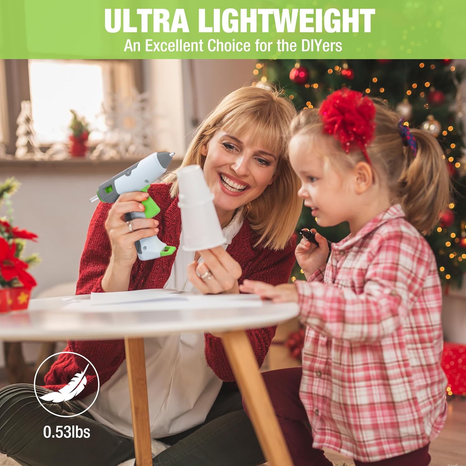 Cordless hot glue gun held in hand, dispensing clear glue for crafting