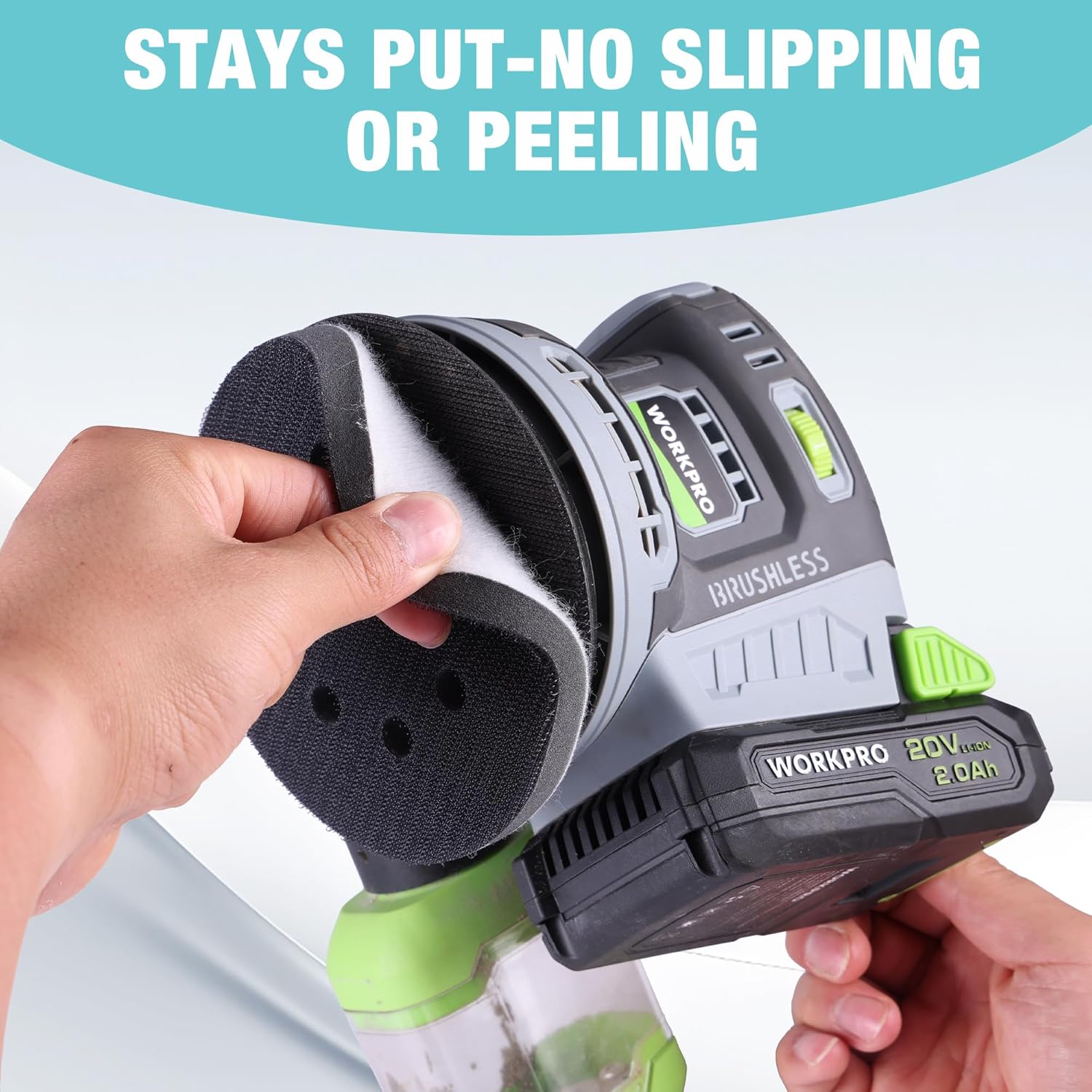Hands holding a WORKPRO orbital sander with attached black sanding pad and disc
