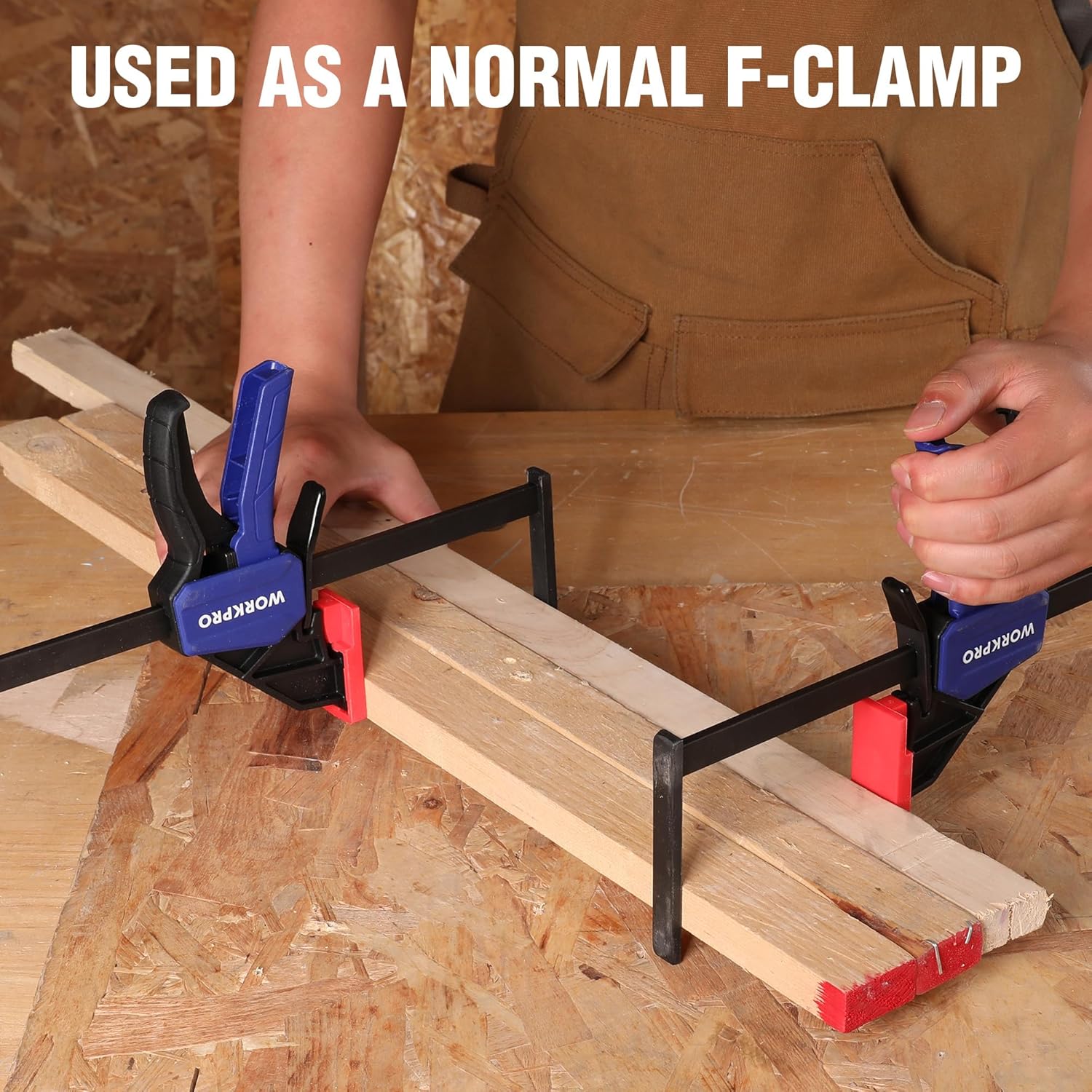 Two WORKPRO clamps securing wood boards with black arms and red throat pads.