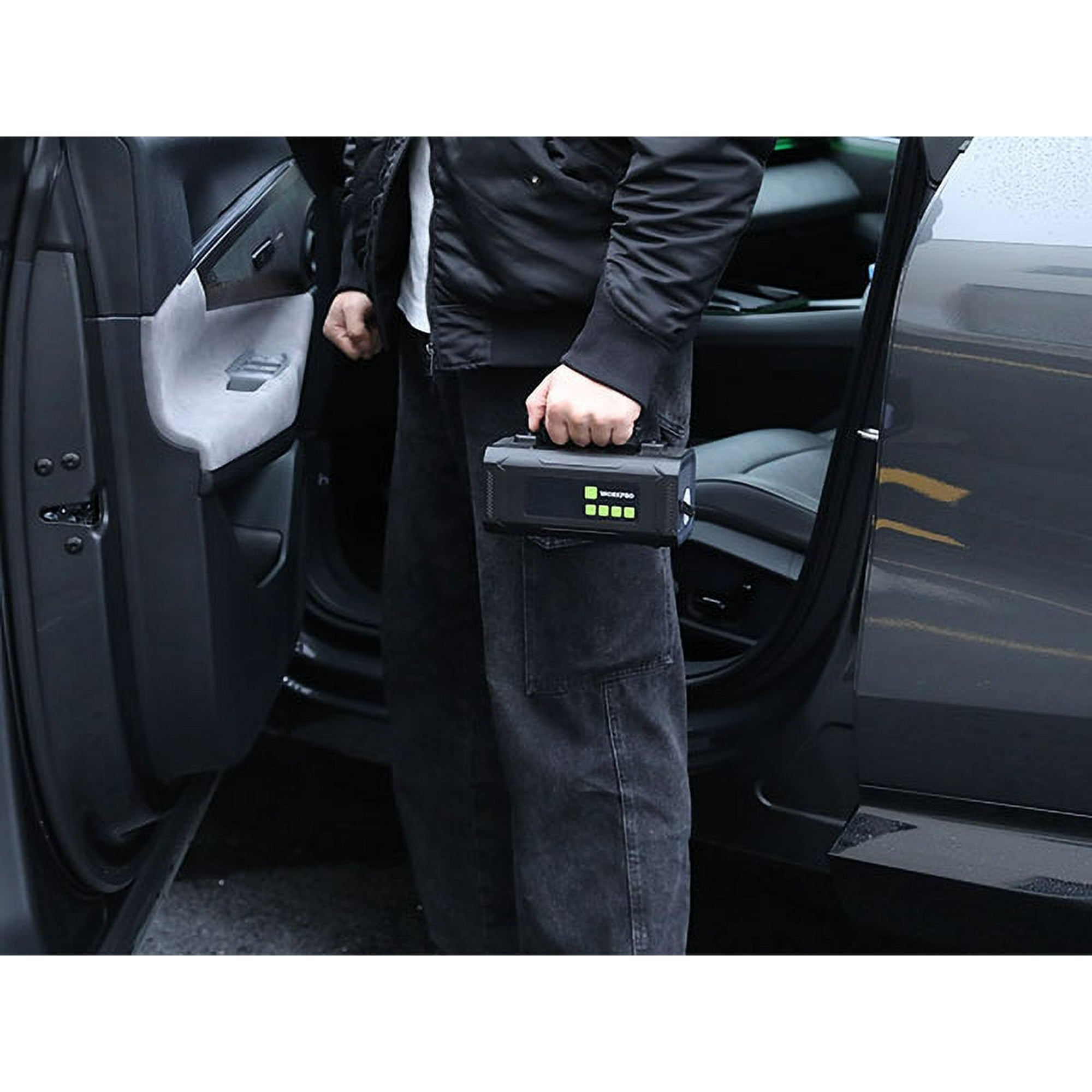 Hand holding WORKPRO 12V portable air compressor with glowing digital display near car door