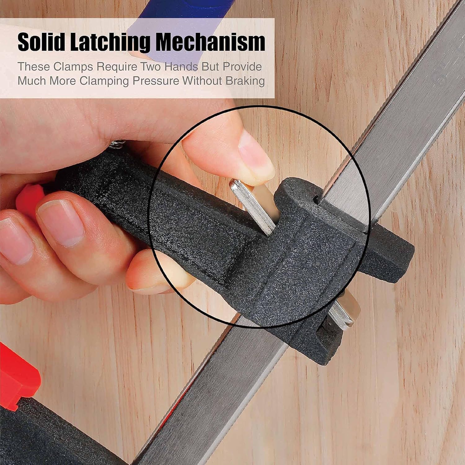 Bar clamp latch engaged on wood, black textured jaws, steel bar with threaded screw
