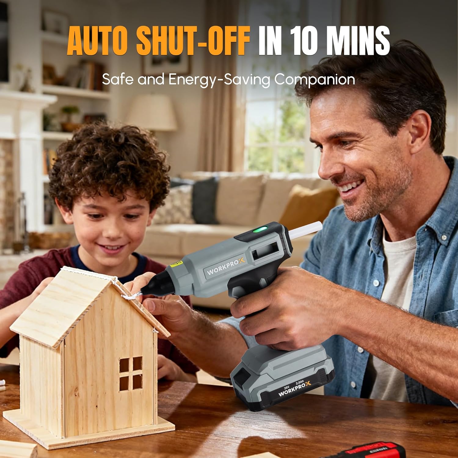 Cordless hot glue gun held in hands, gray and black body heating onto wooden project
