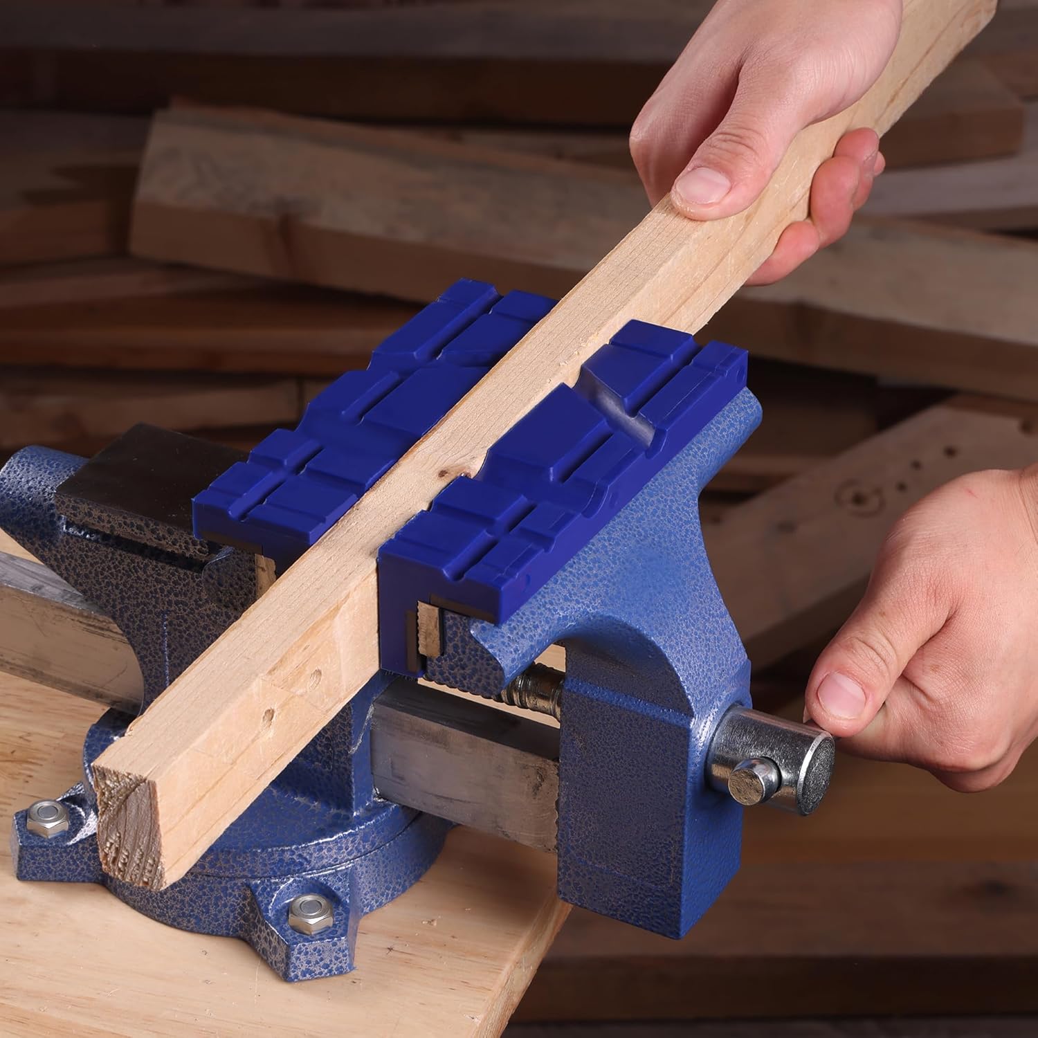 Blue TPU vise jaw pads clamping a wooden board on a bench vise