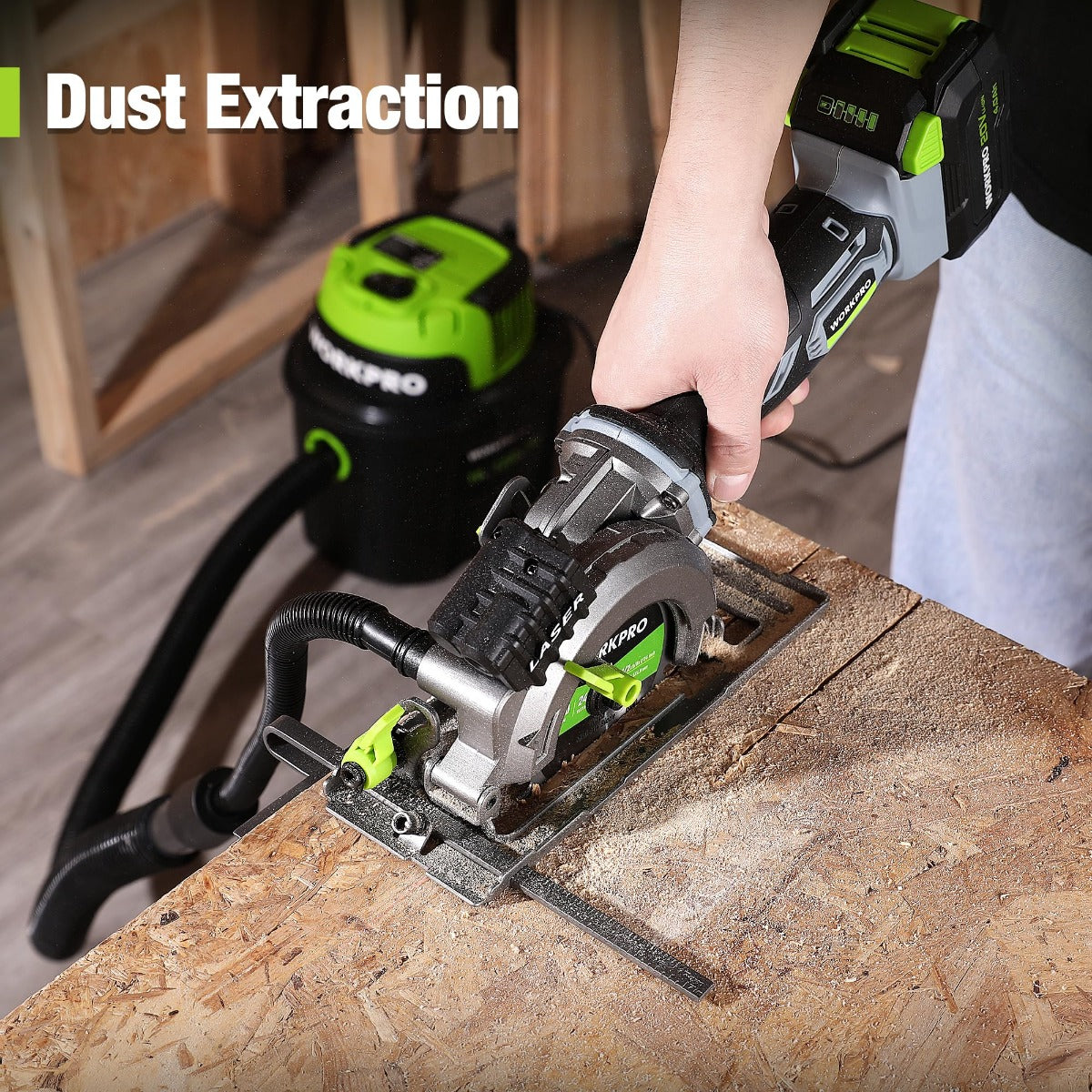 Cordless mini circular saw with dust extraction port connected to a vacuum hose