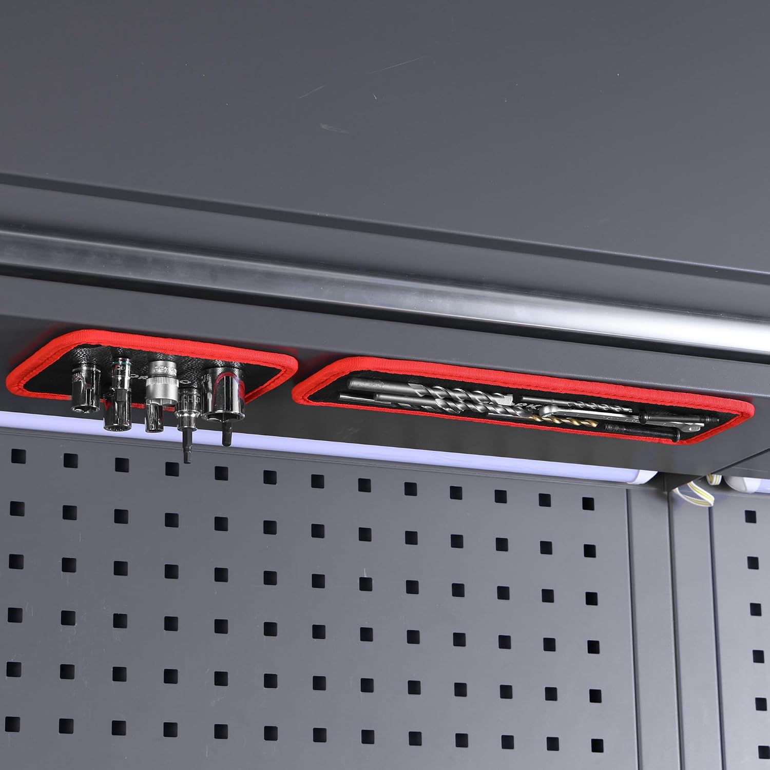 Red-edged magnetic tool holder pads mounted on a pegboard with tools in place