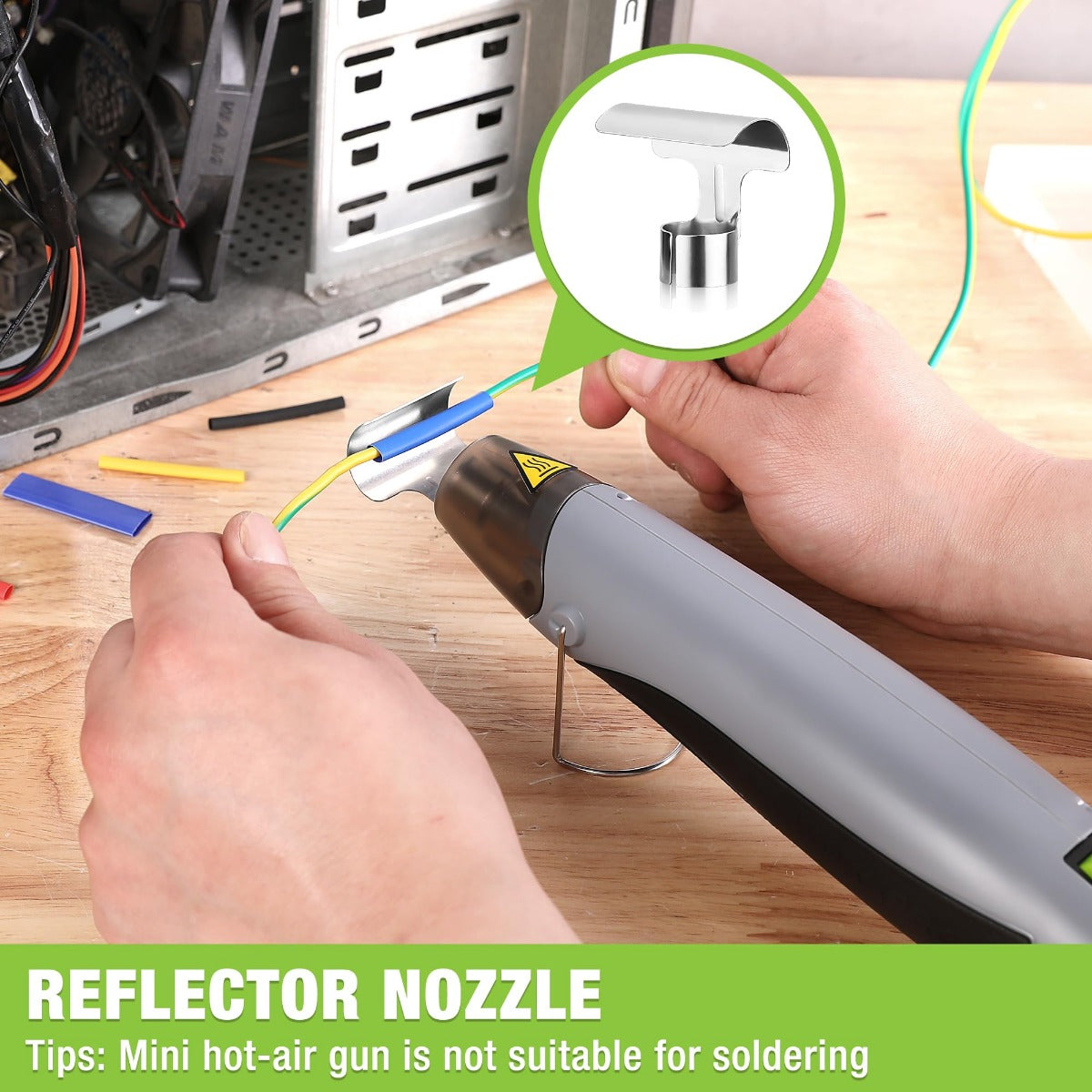 Grey mini hot air gun with reflector nozzle, hand holding the trigger