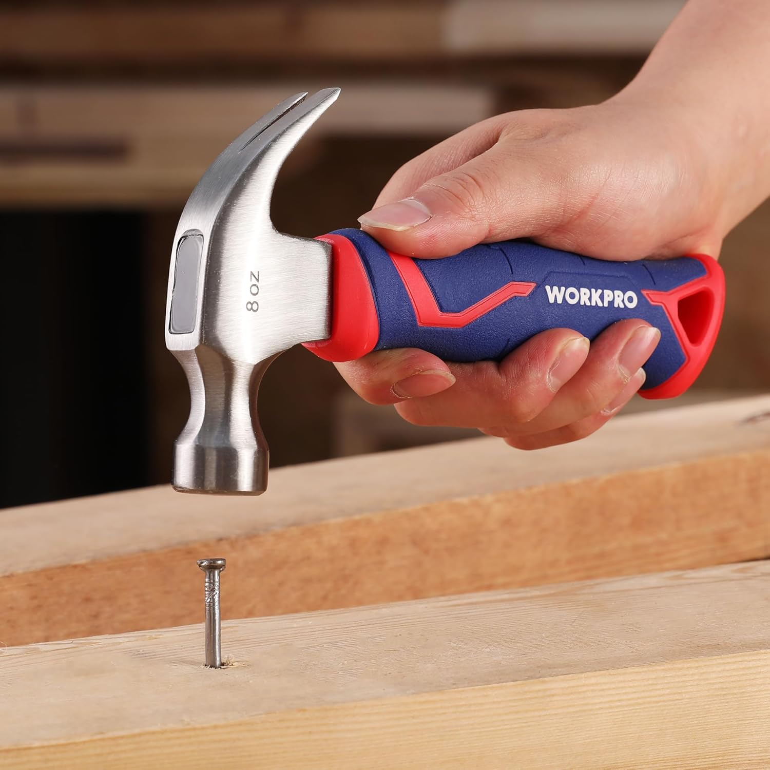 8 oz claw hammer with steel head and blue-red fiberglass handle, held in hand