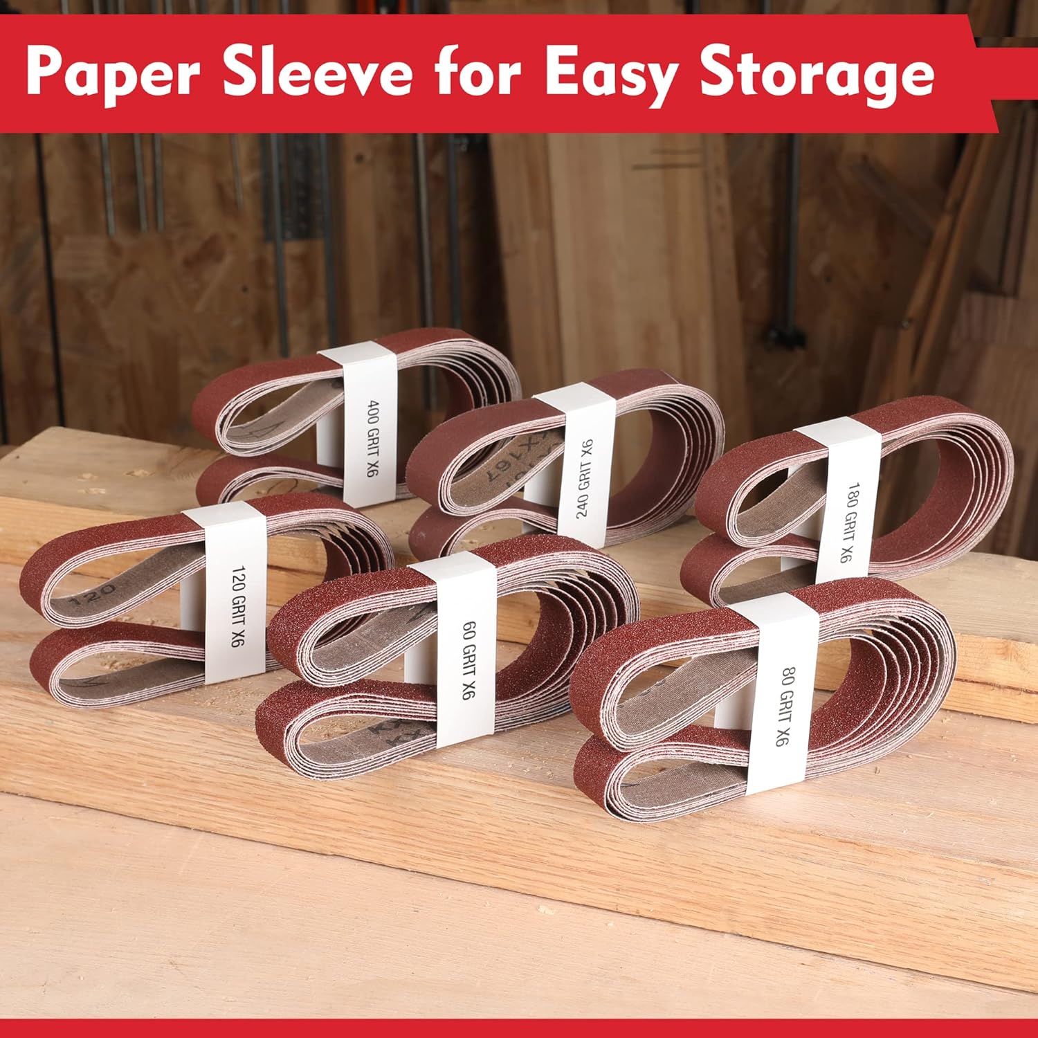 Rolled maroon sanding belts with white paper sleeves for easy storage