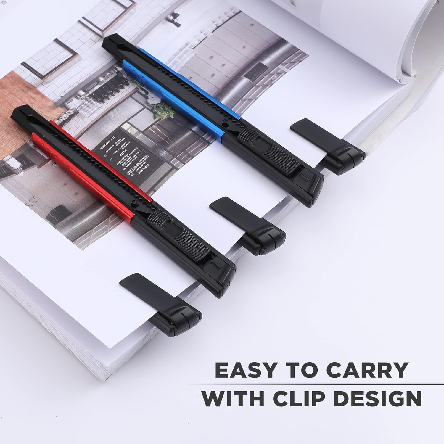Retractable snap-off box cutter knives lying on paper sheets, black handles with colored accents