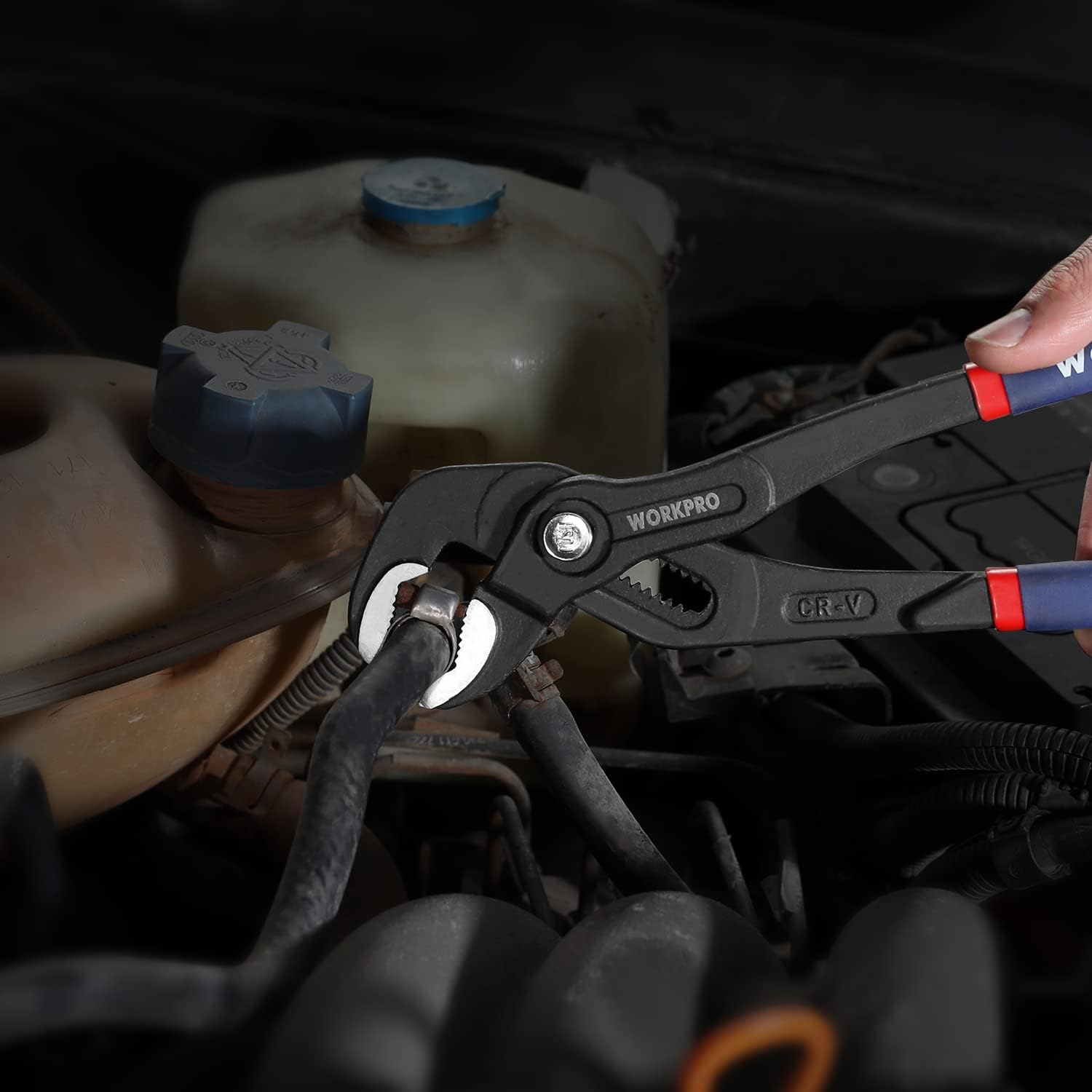 V-jaw groove joint pliers with blue handles on an engine bay tool area