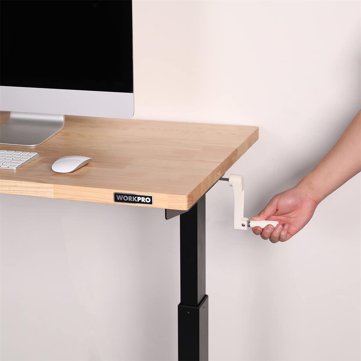 Height-adjustable work table with light wood top and hand-adjusted leveling foot on black leg.