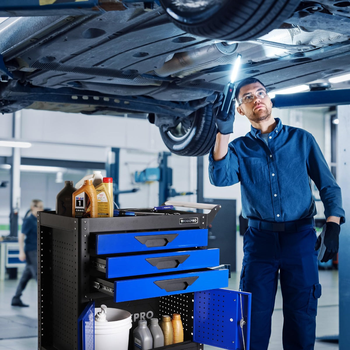 WORKPRO rolling tool chest under vehicle access area with blue drawers and cabinet door