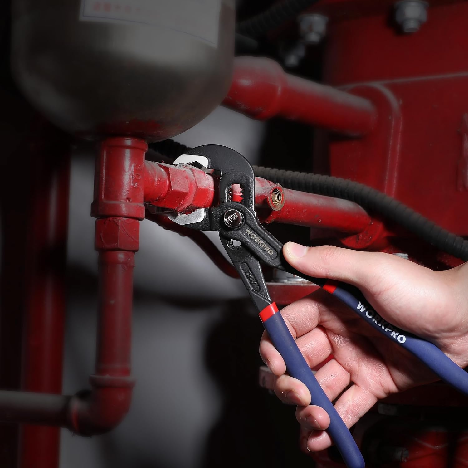 Groove joint pliers being used on a pipe fitting with blue handles