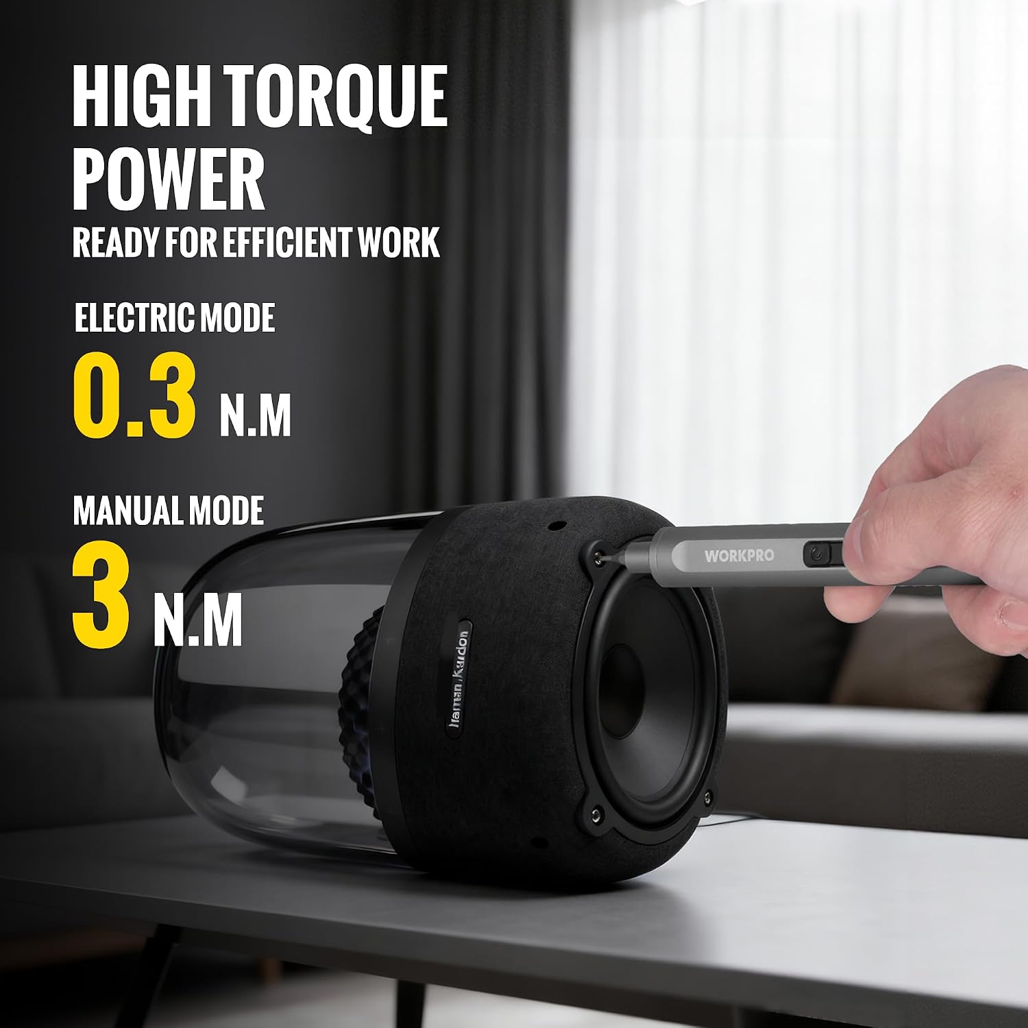 Black precision electric screwdriver head with silver shaft, held in hand near workbench