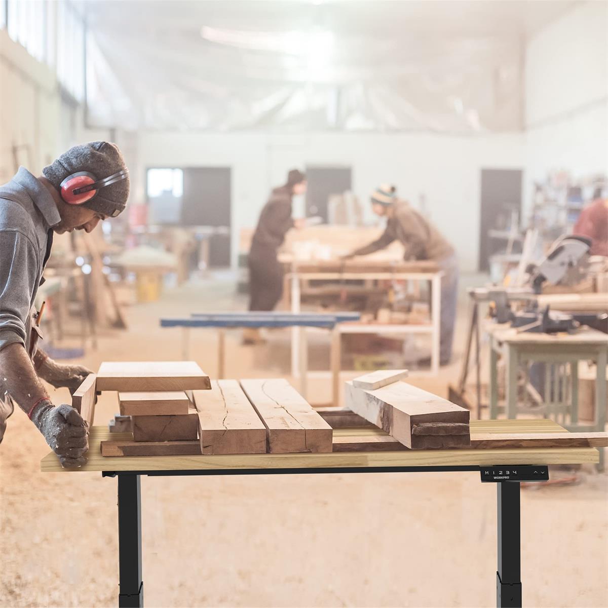 Height adjustable workbench with light wood work surface and black legs