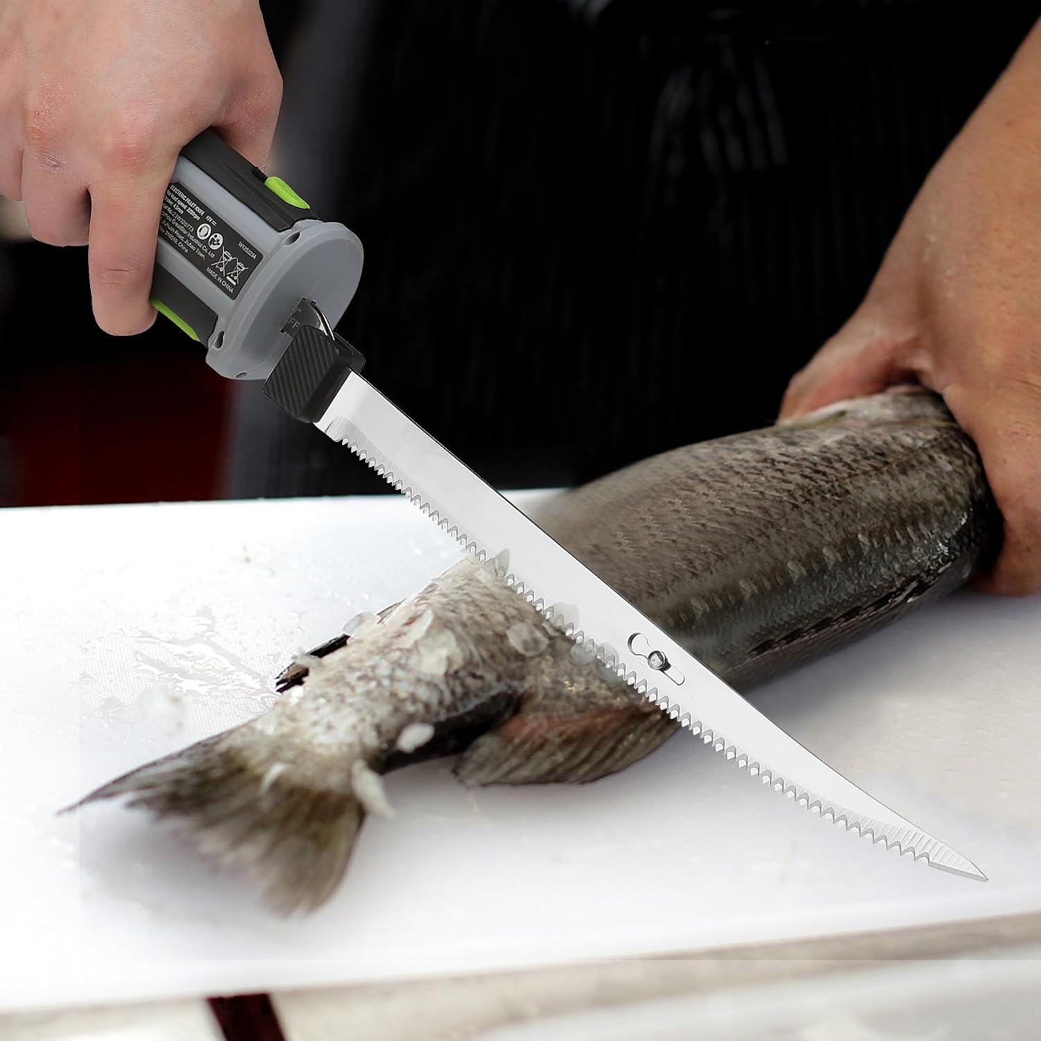 Replacement fillet knife blade cutting a whole fish on a white tray.