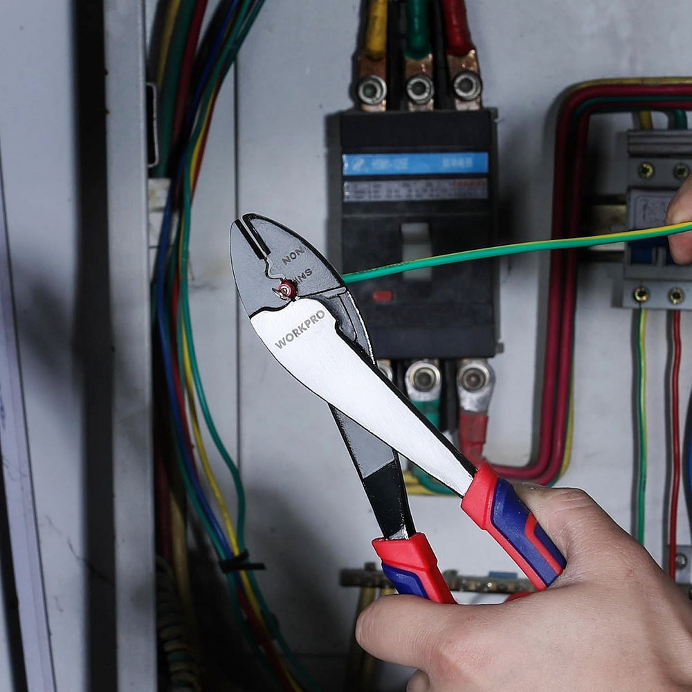 Wire cutter crimper tool cutting a green wire in an electrical panel