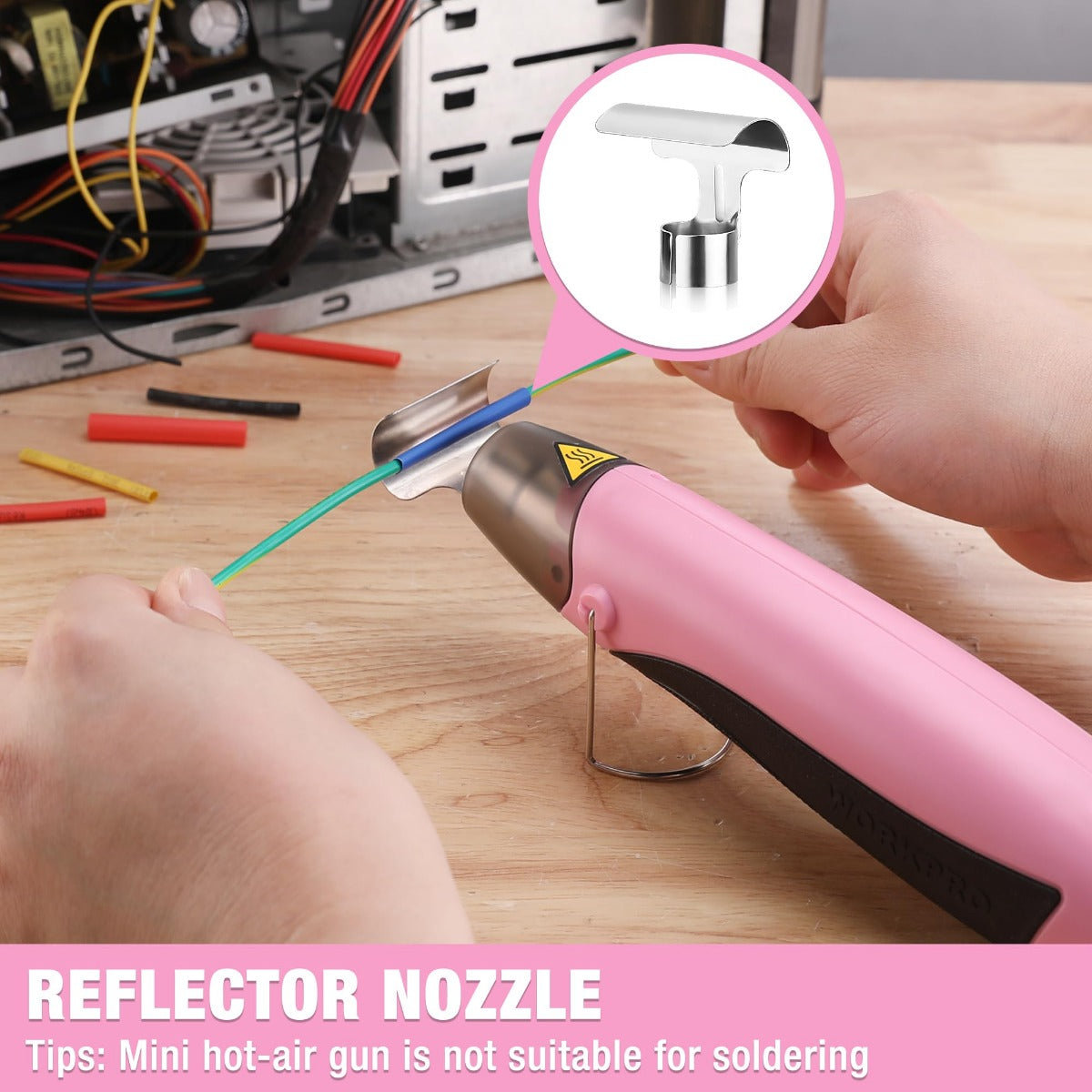 Hand using pink hot air gun with reflector nozzle and heat shield on workbench