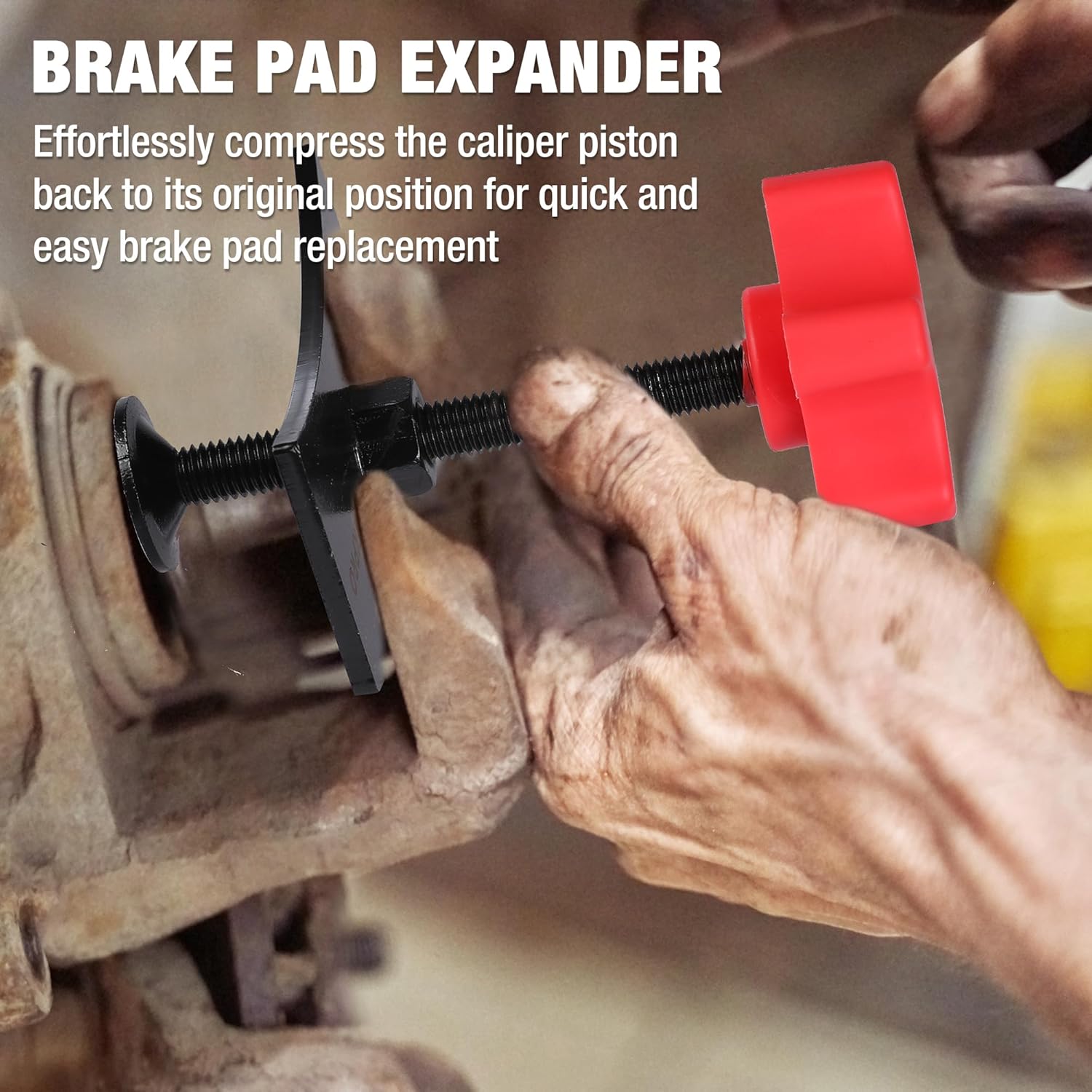 Brake pad expander tool compressing brake caliper piston, red clamp and black plates