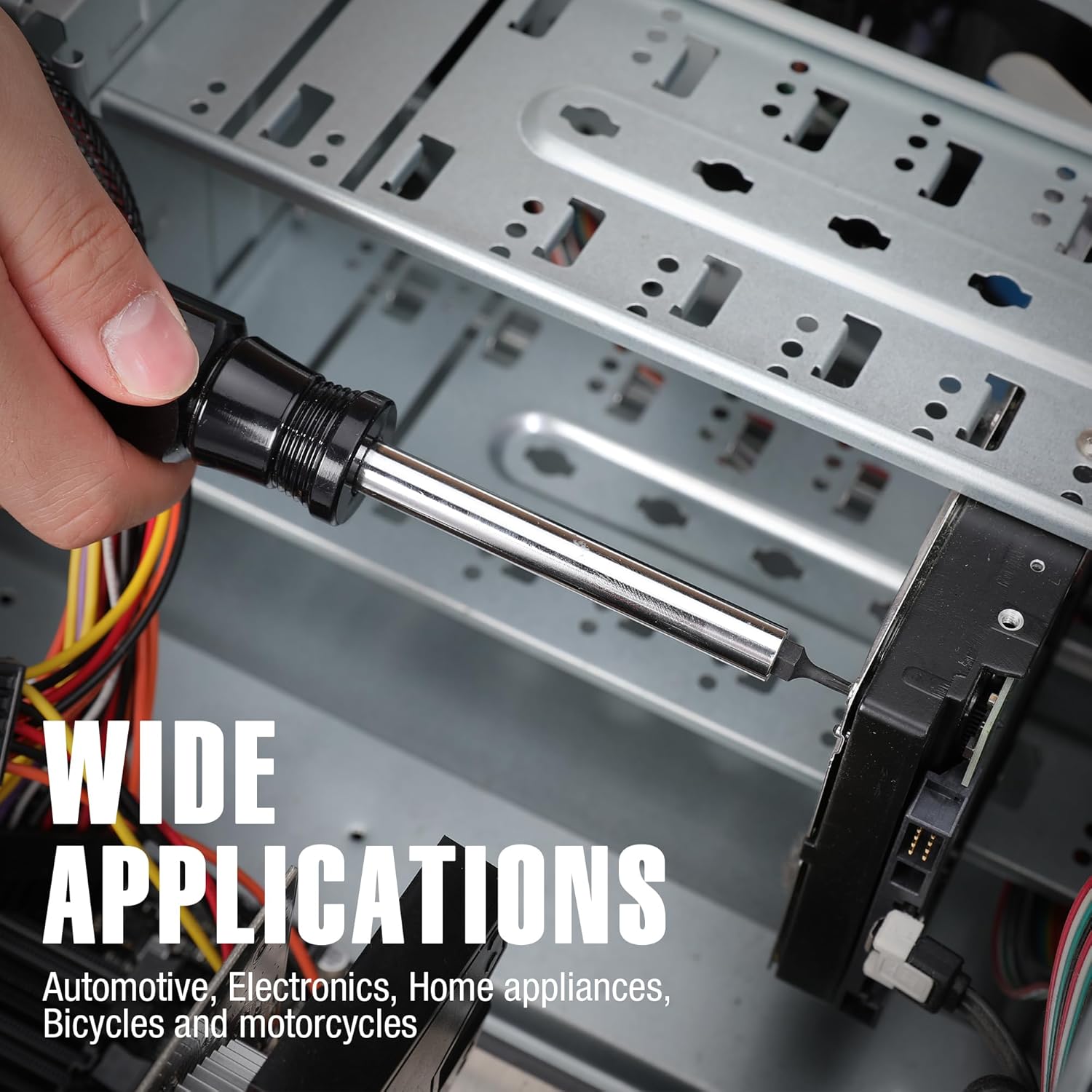 Hand holding a black tamper-proof Torx bit on a metal device panel with wires