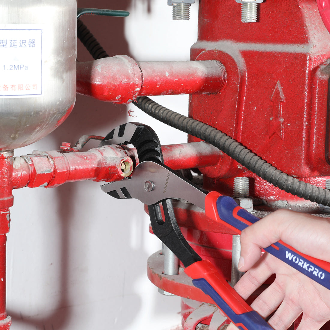 WORKPRO adjustable water pump pliers applying grip to a red pipe connection
