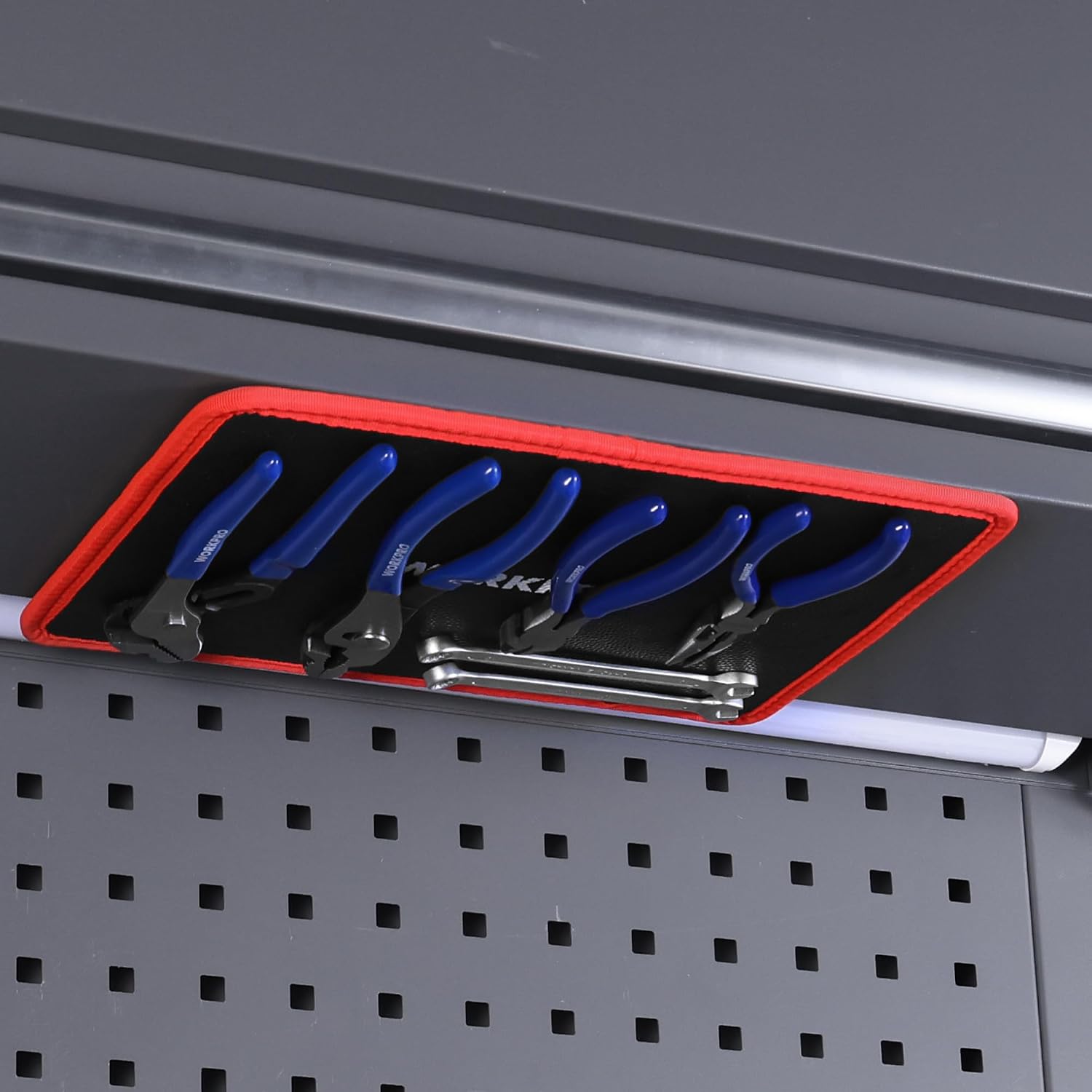 Flexible magnetic tool tray on metal rail, black interior with red trim; blue-handled tools.