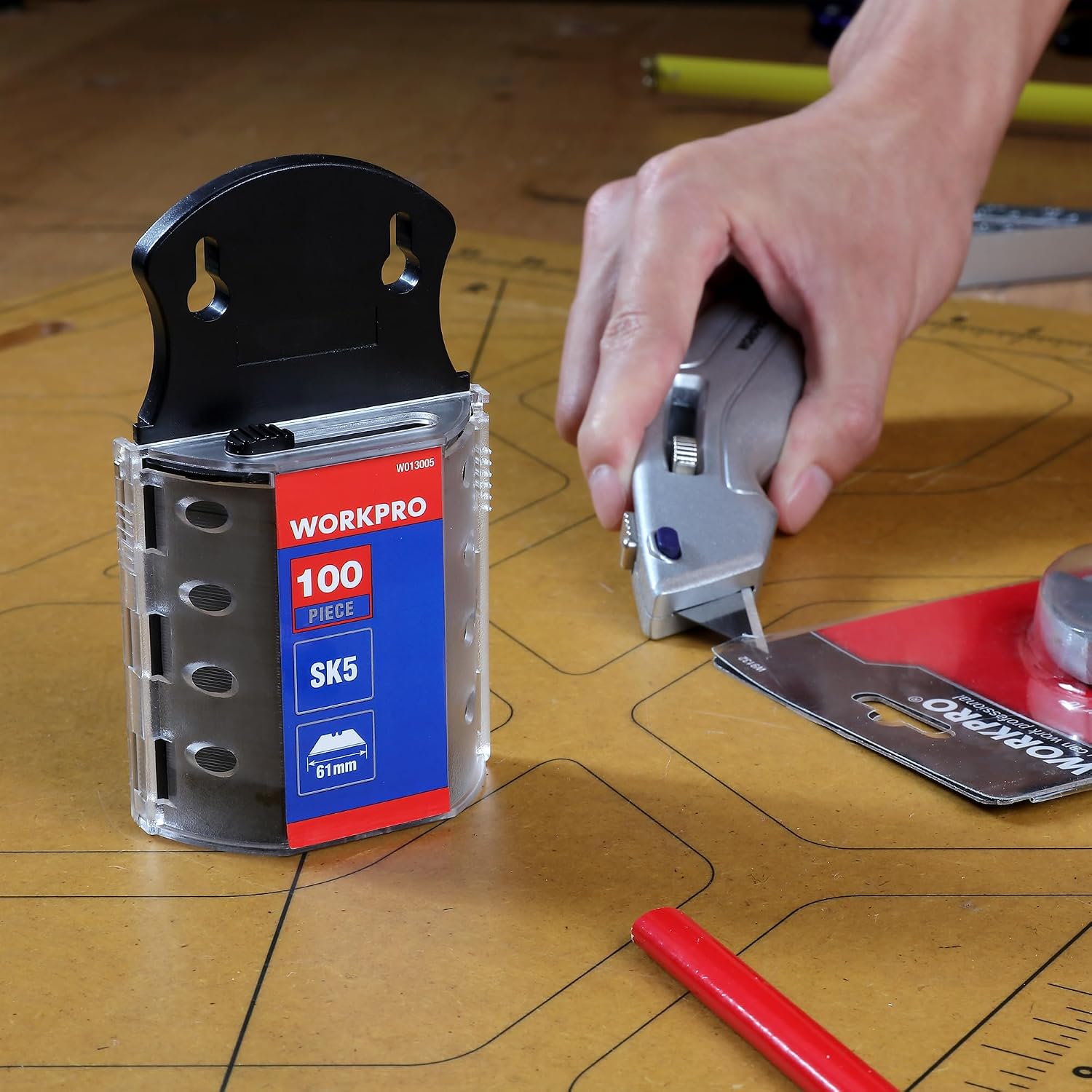 Utility knife blade change setup with dispenser and installed blade on workbench