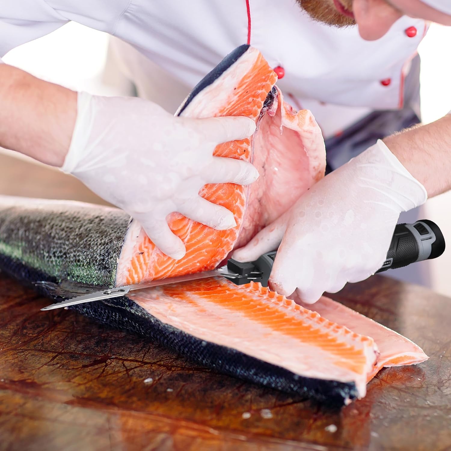 Serrated replacement blade cutting fish fillet with gloved hands