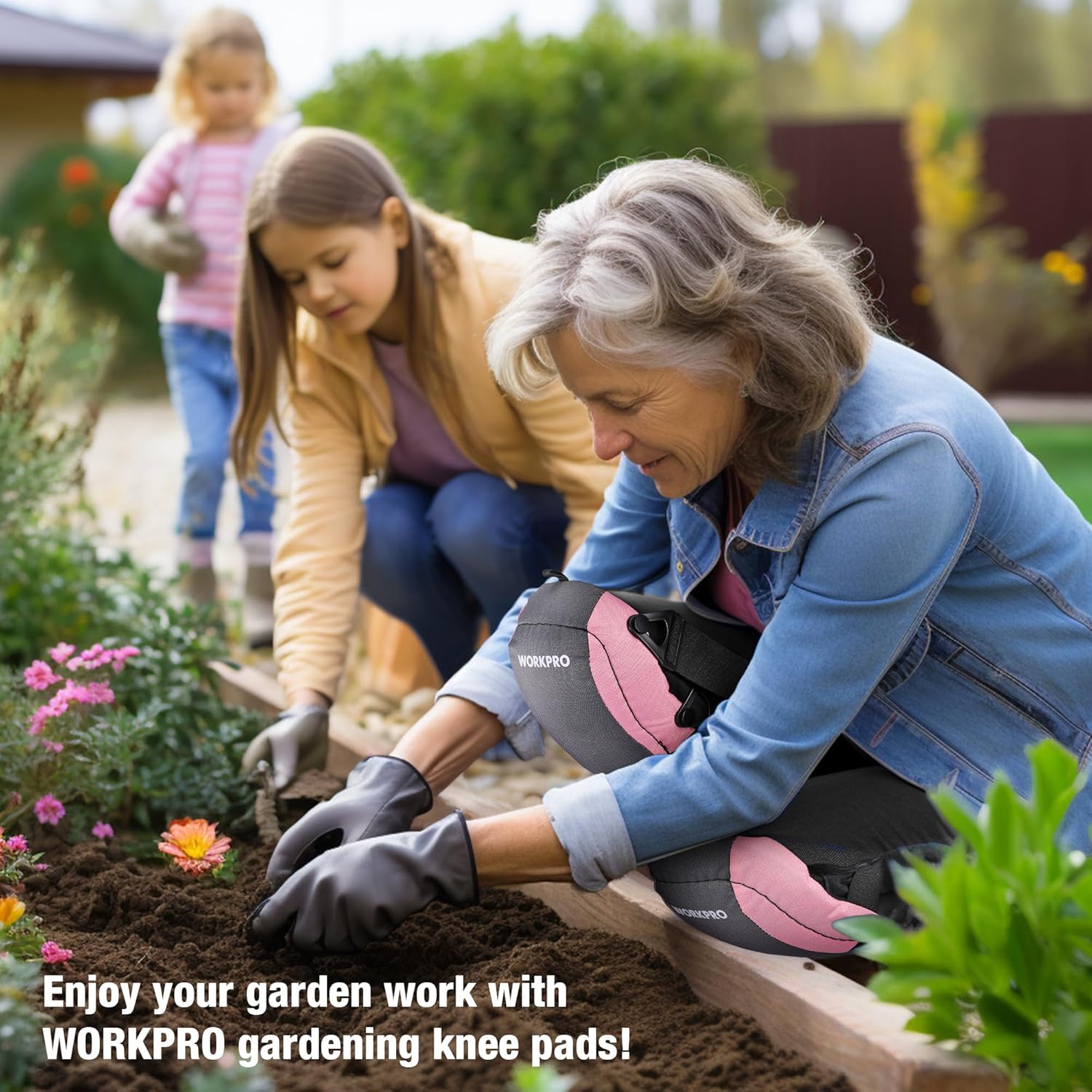 Pink and gray knee pads with black straps worn in a garden while kneeling.