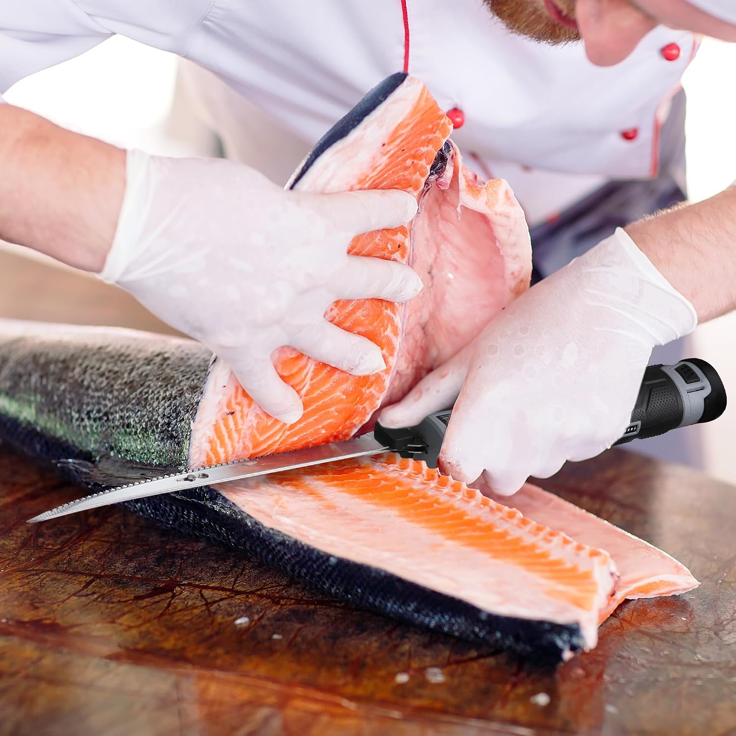 Serrated fillet knife blade cutting salmon fillet on cutting board.