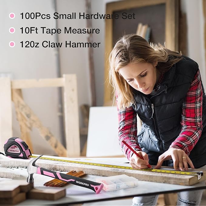 Pink DIY tool set with tape measure and claw hammer, arranged on a workbench