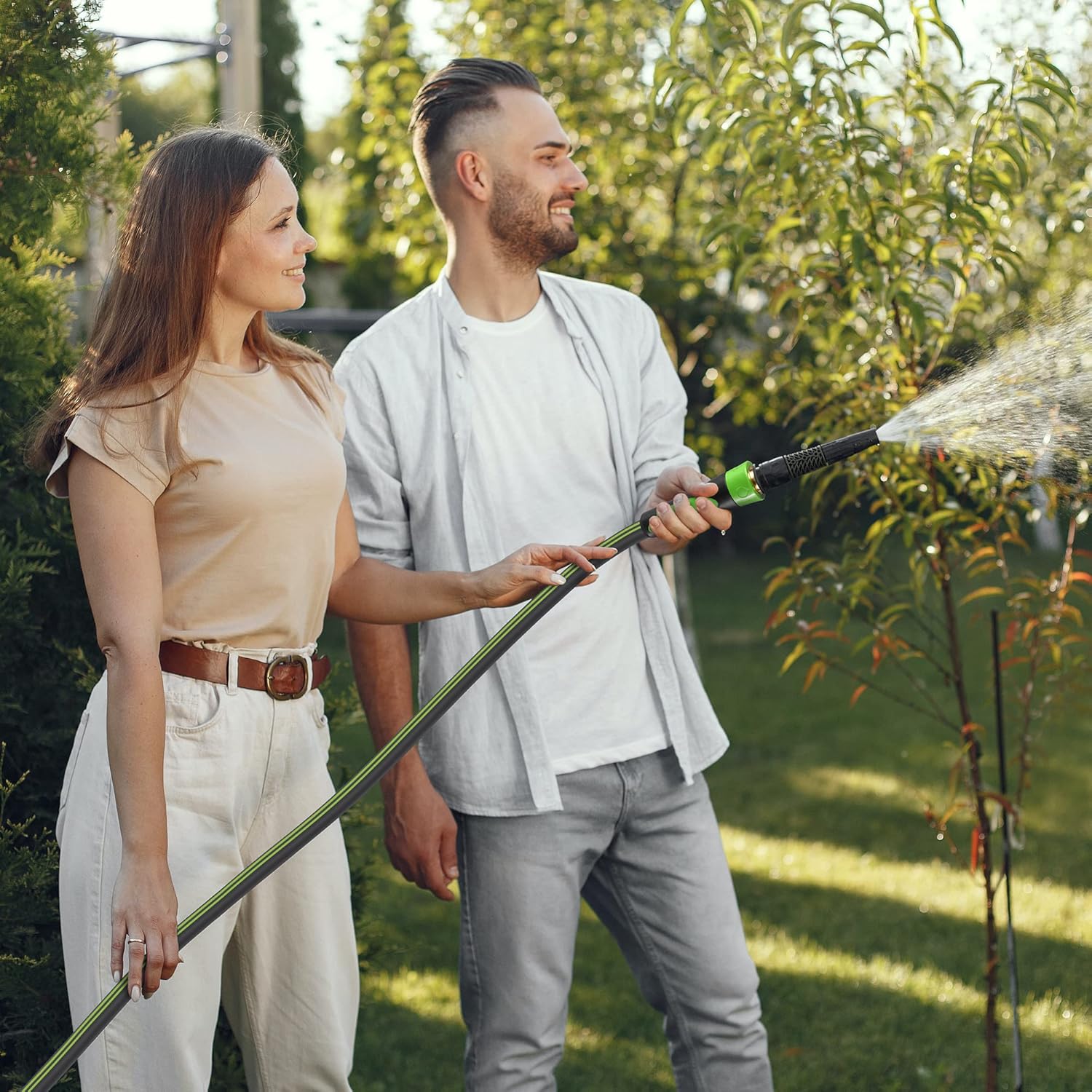 Garden hose spraying with green nozzle and dark-and-green tubing