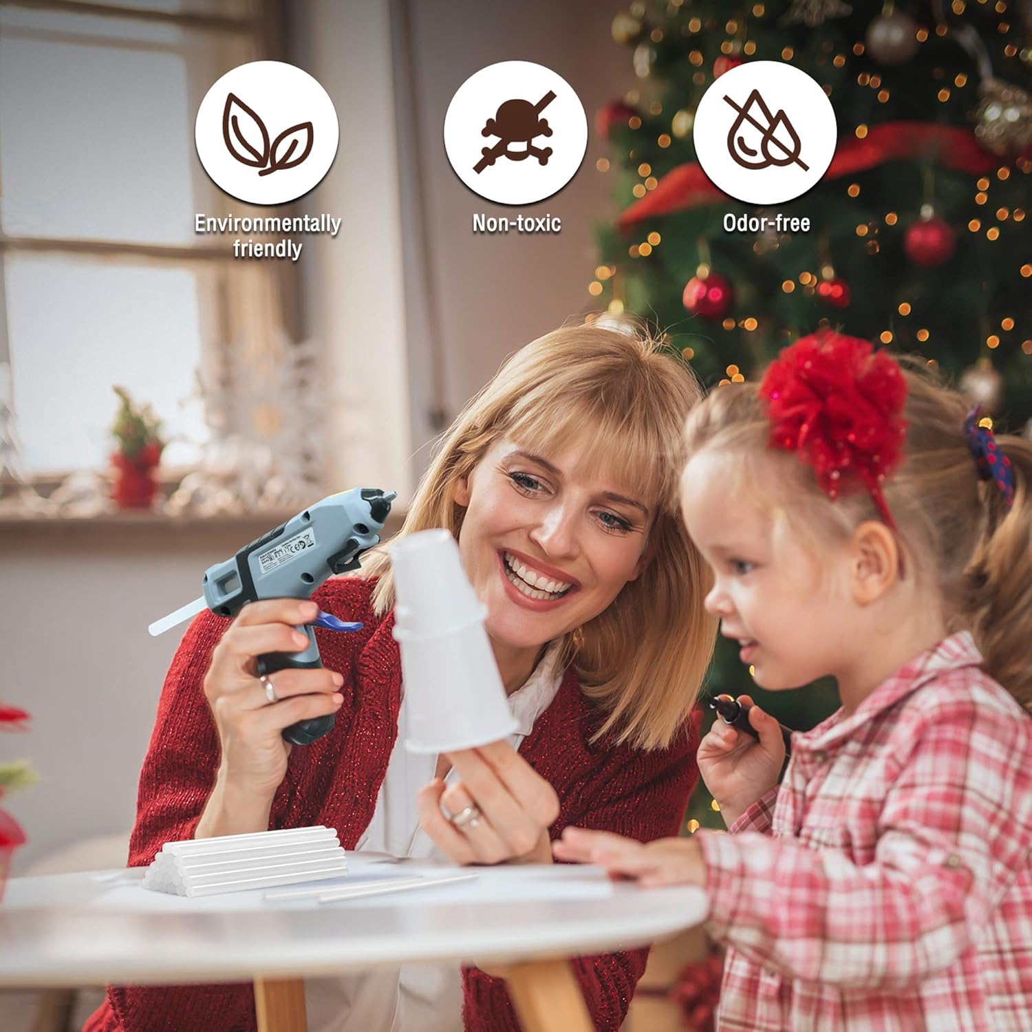 Hot glue sticks and glue gun for DIY crafts, used by parent and child at table