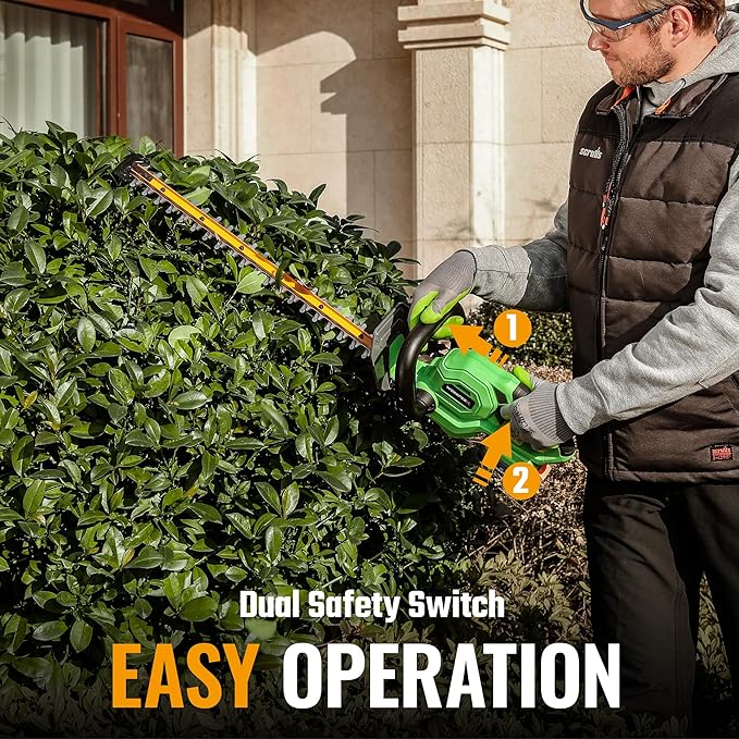Cordless hedge trimmer used by gardener for trimming a dense hedge