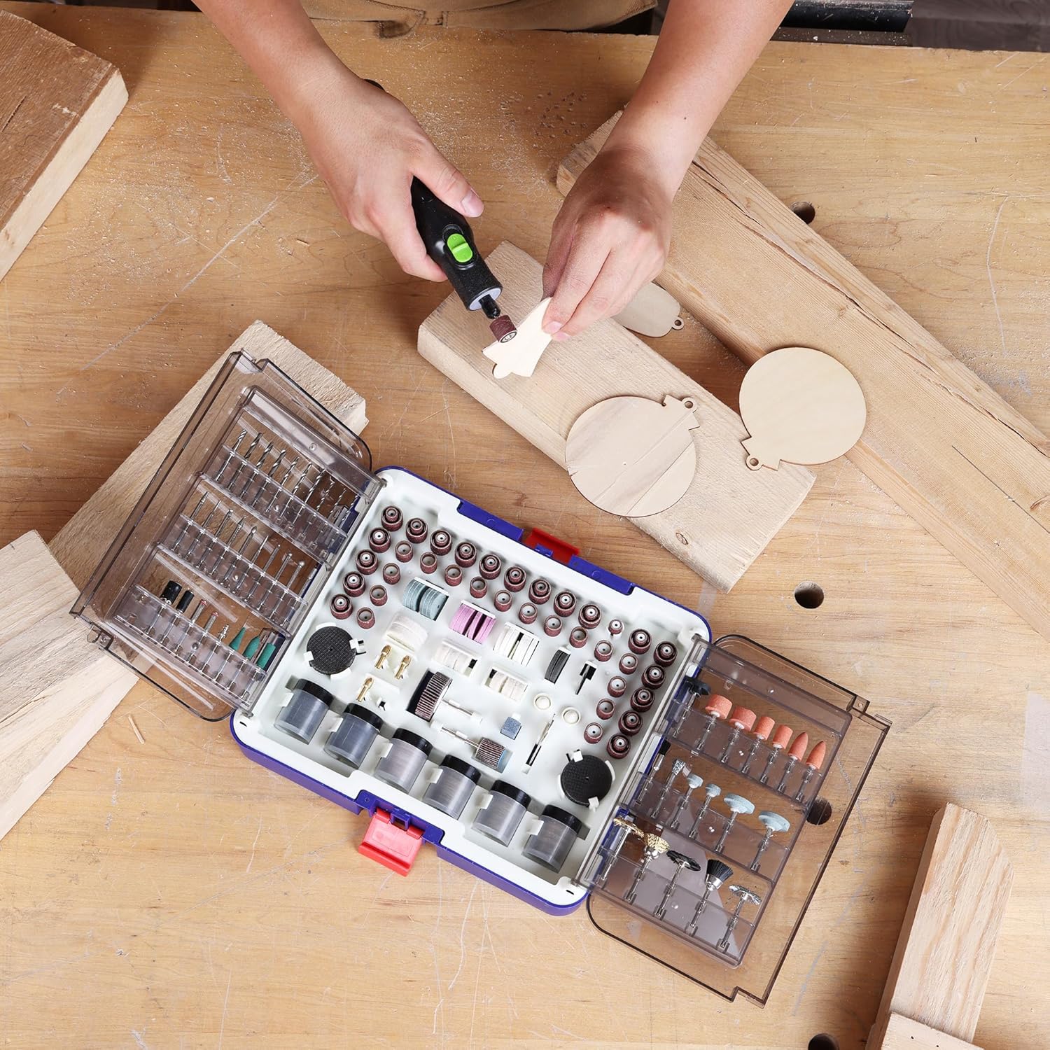 Rotary tool accessory kit with rotary bits and sanding tools on a wood workbench
